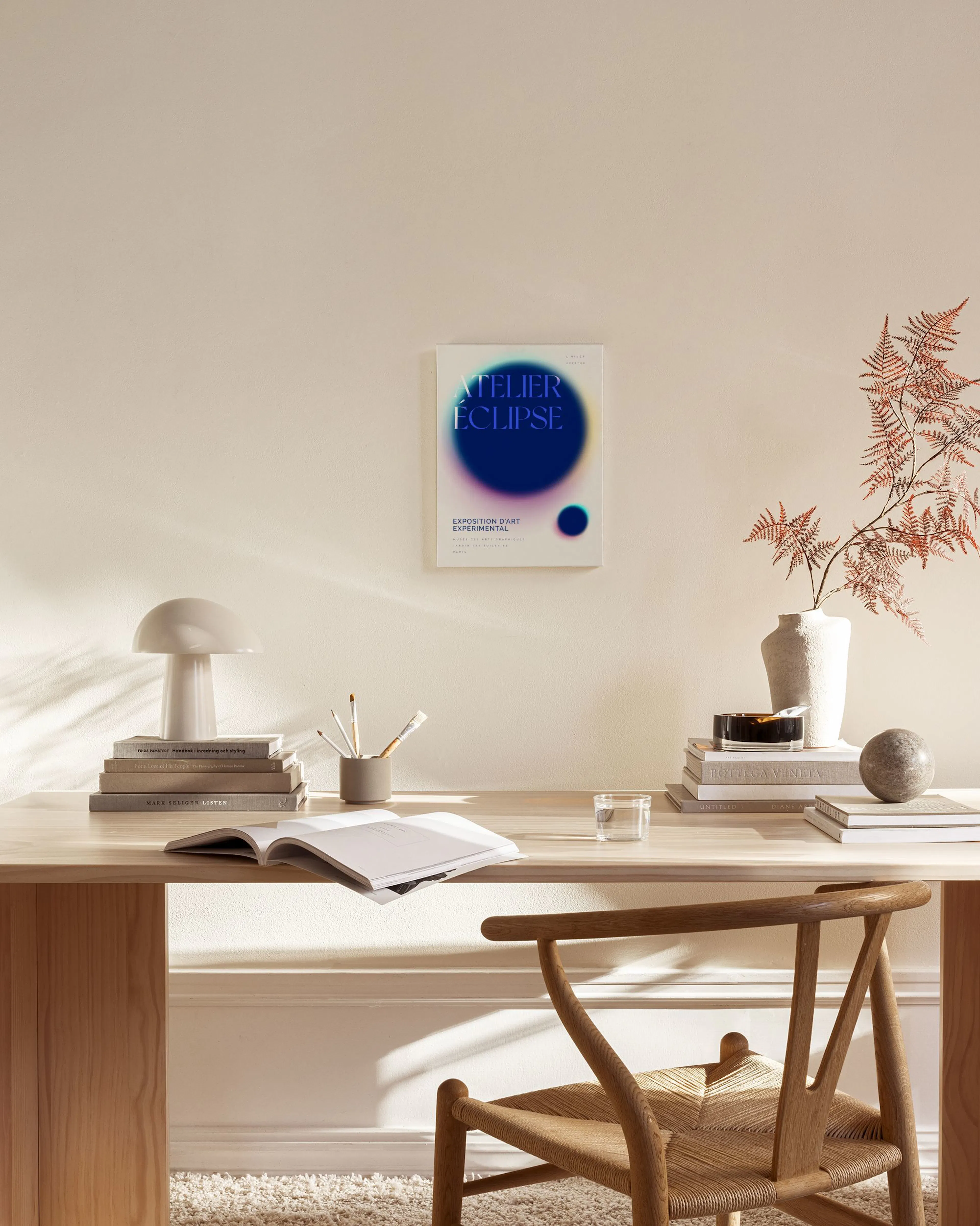 Canvas met blauw-paarse, wazige cirkels en de tekst ATELIER ÉCLIPSE, hangend in een moderne woonkamer.