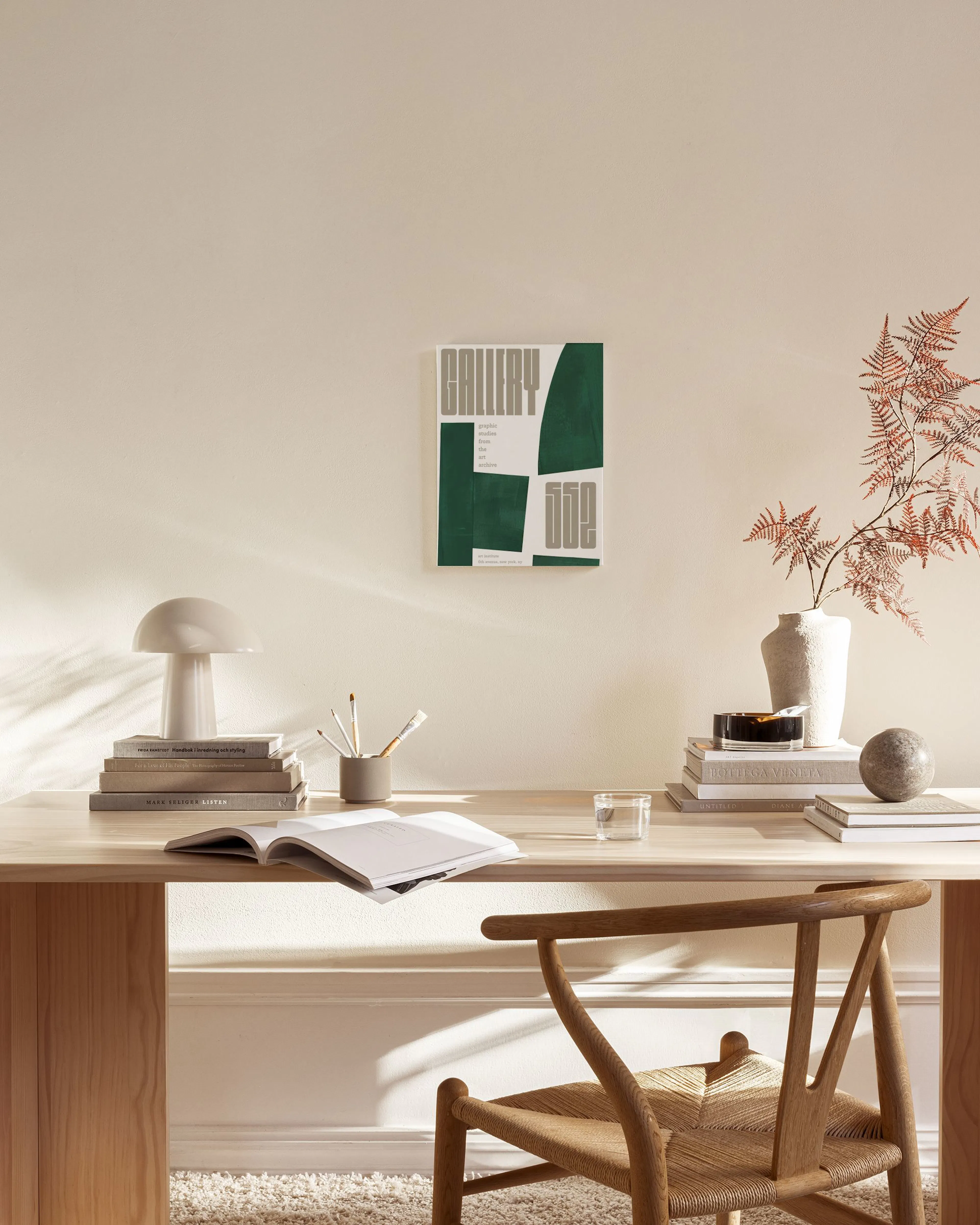 Leinwandbild mit dunkelgrünen und grauen geometrischen Formen und Text, hängt in einem modernen Wohnzimmer über einem Sideboard.