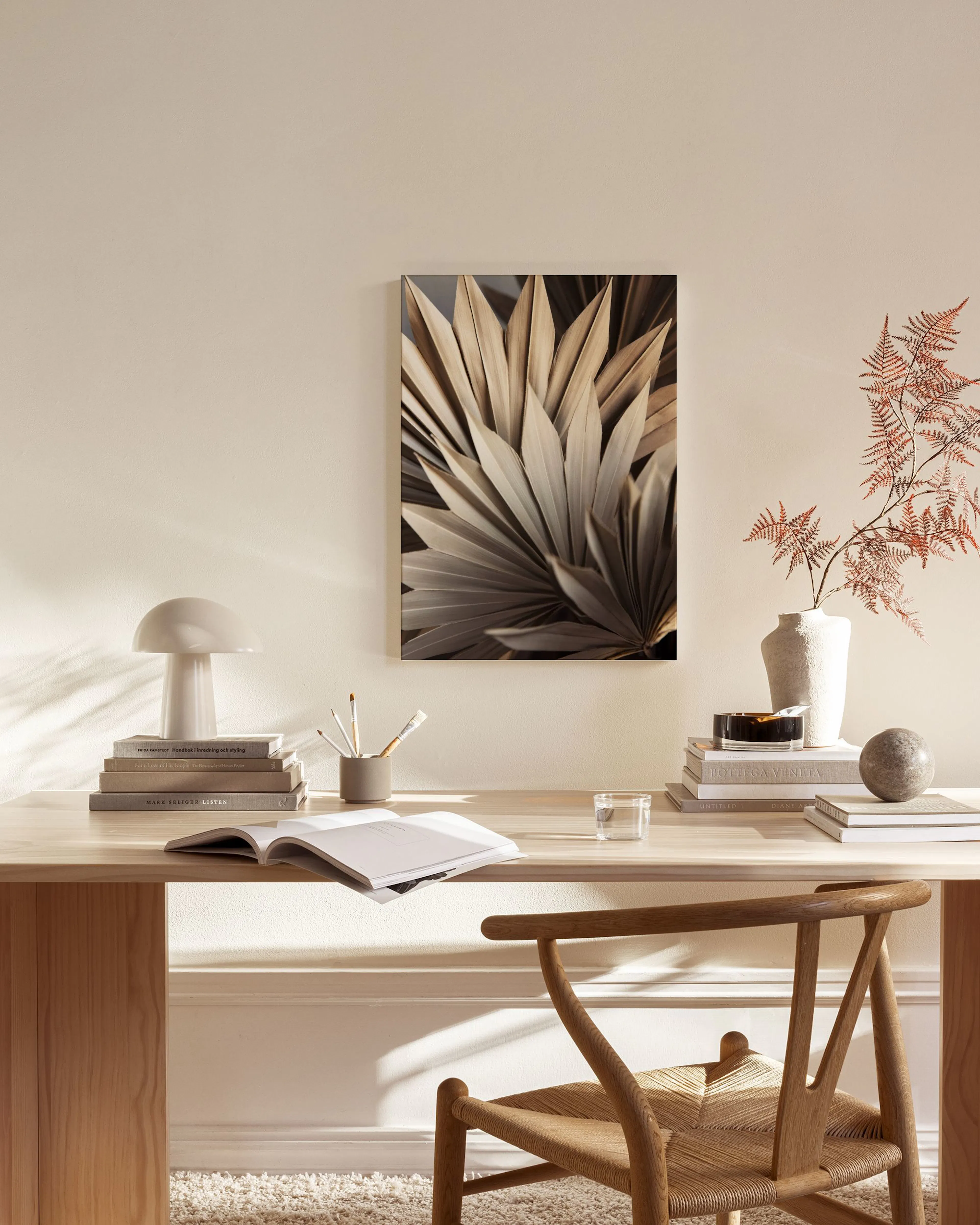 Lienzo de hojas de palma secas en tonos neutros, colgado en una sala de estar moderna con muebles de madera.