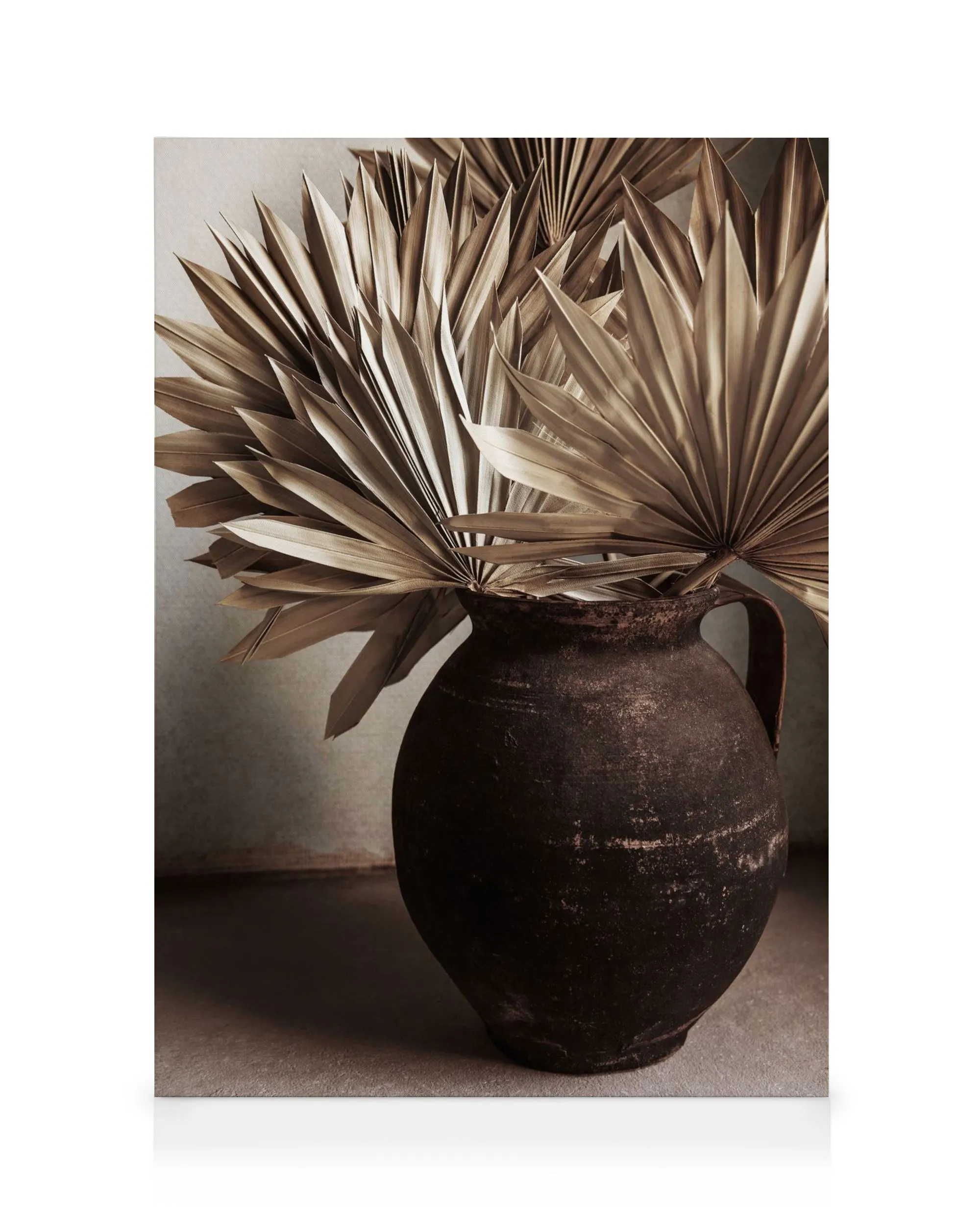Rustic dried palm leaves in a dark, textured clay pot, creating a natural, earthy aesthetic.