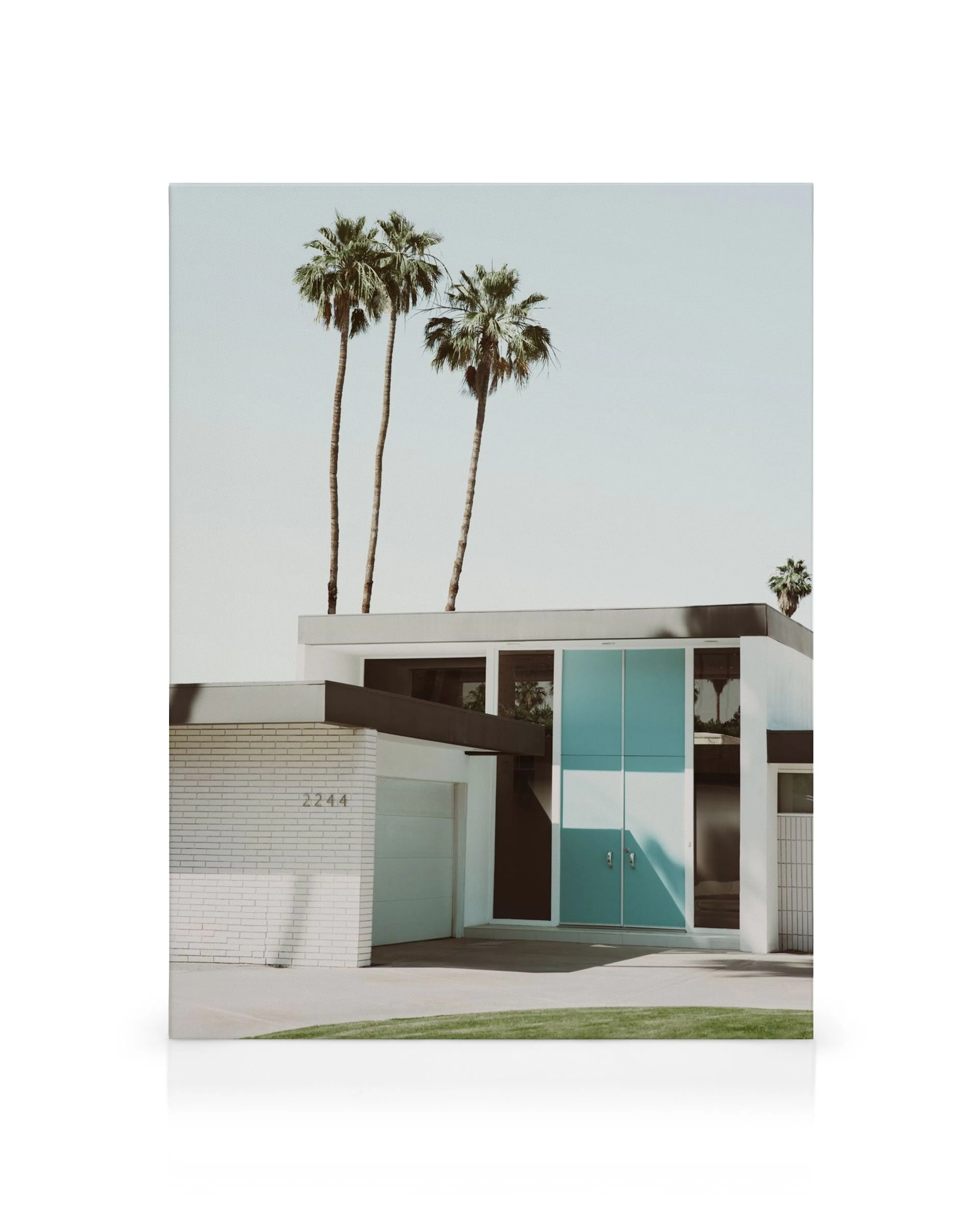 Mid Century Villa Leinwandbild: Moderne Villa mit blauen Türen und Palmen unter hellem Himmel.