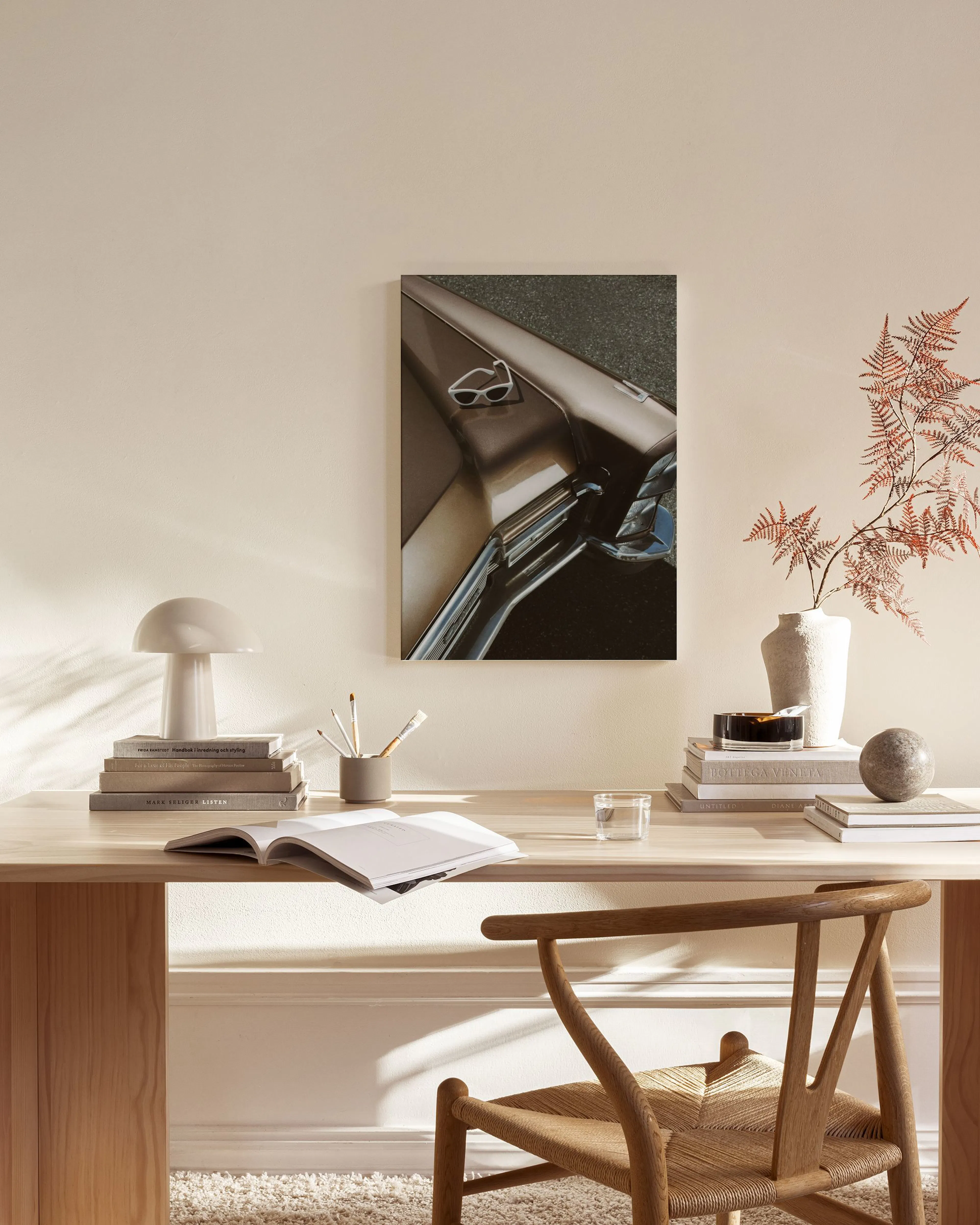 Leinwandbild mit Detailaufnahme der braunen Autotür eines Oldtimers und einer Sonnenbrille, hängend in einem hellen Wohnzimmer.