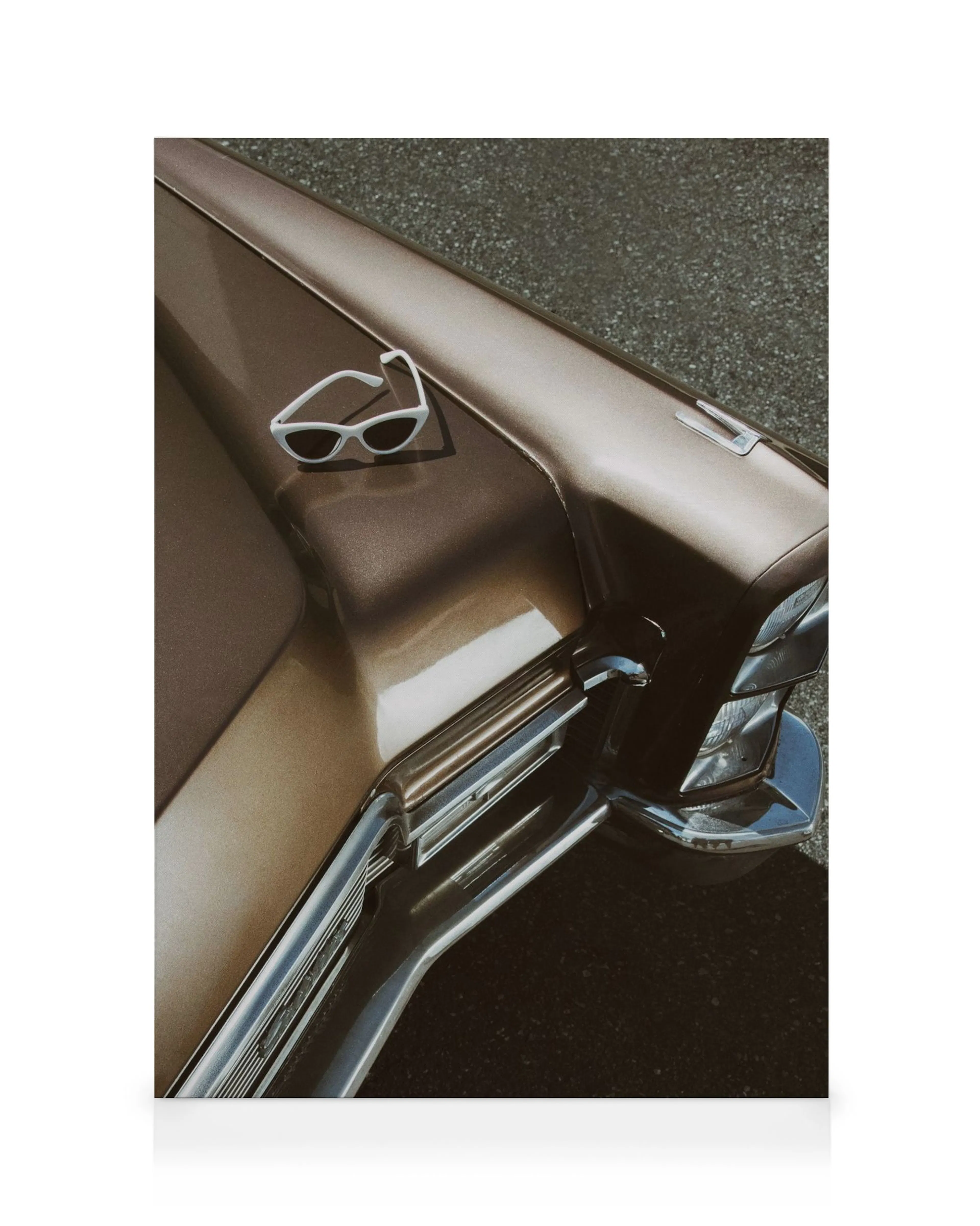 Brauner Cadillac Oldtimer mit weißer Sonnenbrille auf der Motorhaube.