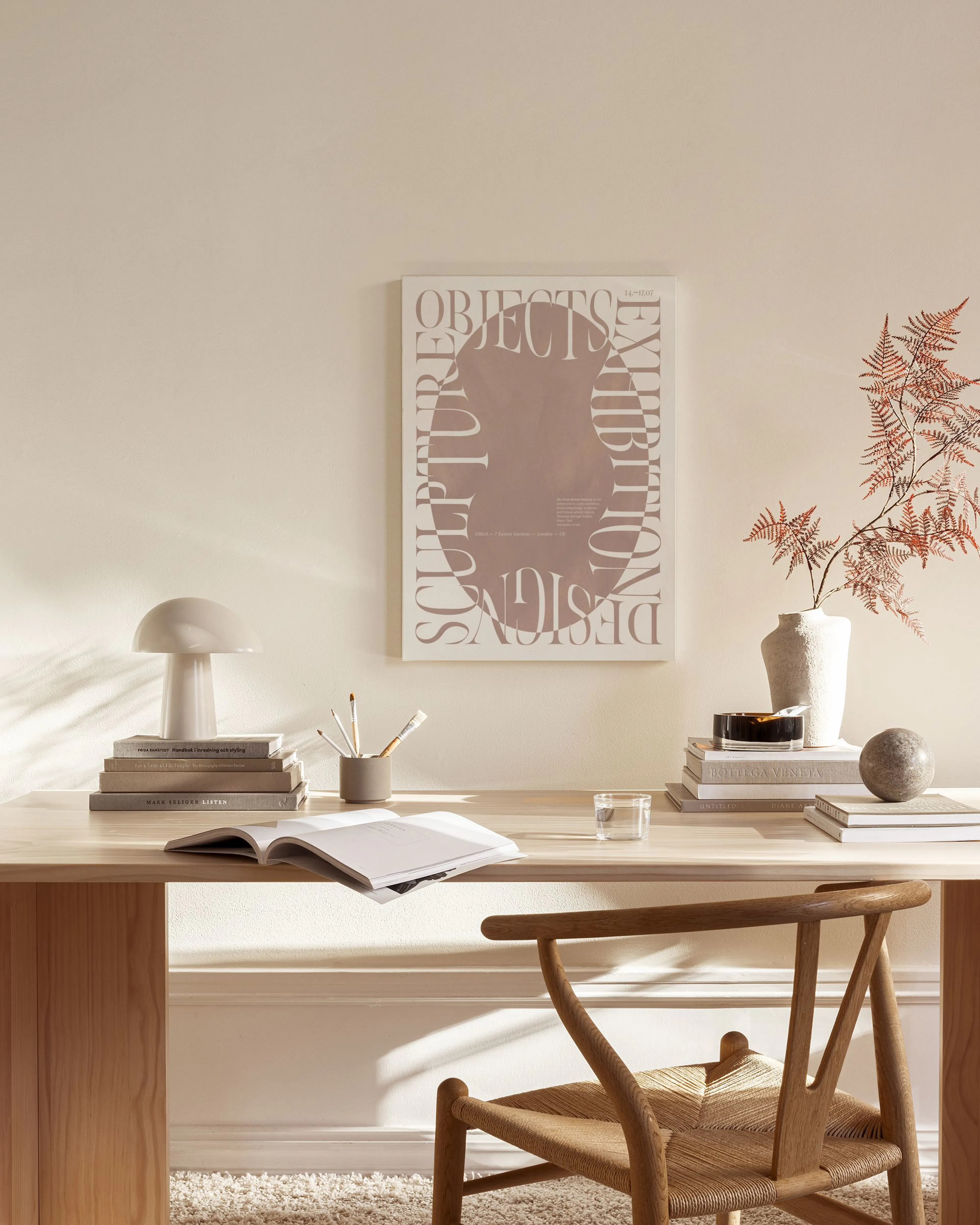 Een canvas met abstracte typografie in een ovale vorm, hangend boven een houten dressoir in een lichte woonkamer.