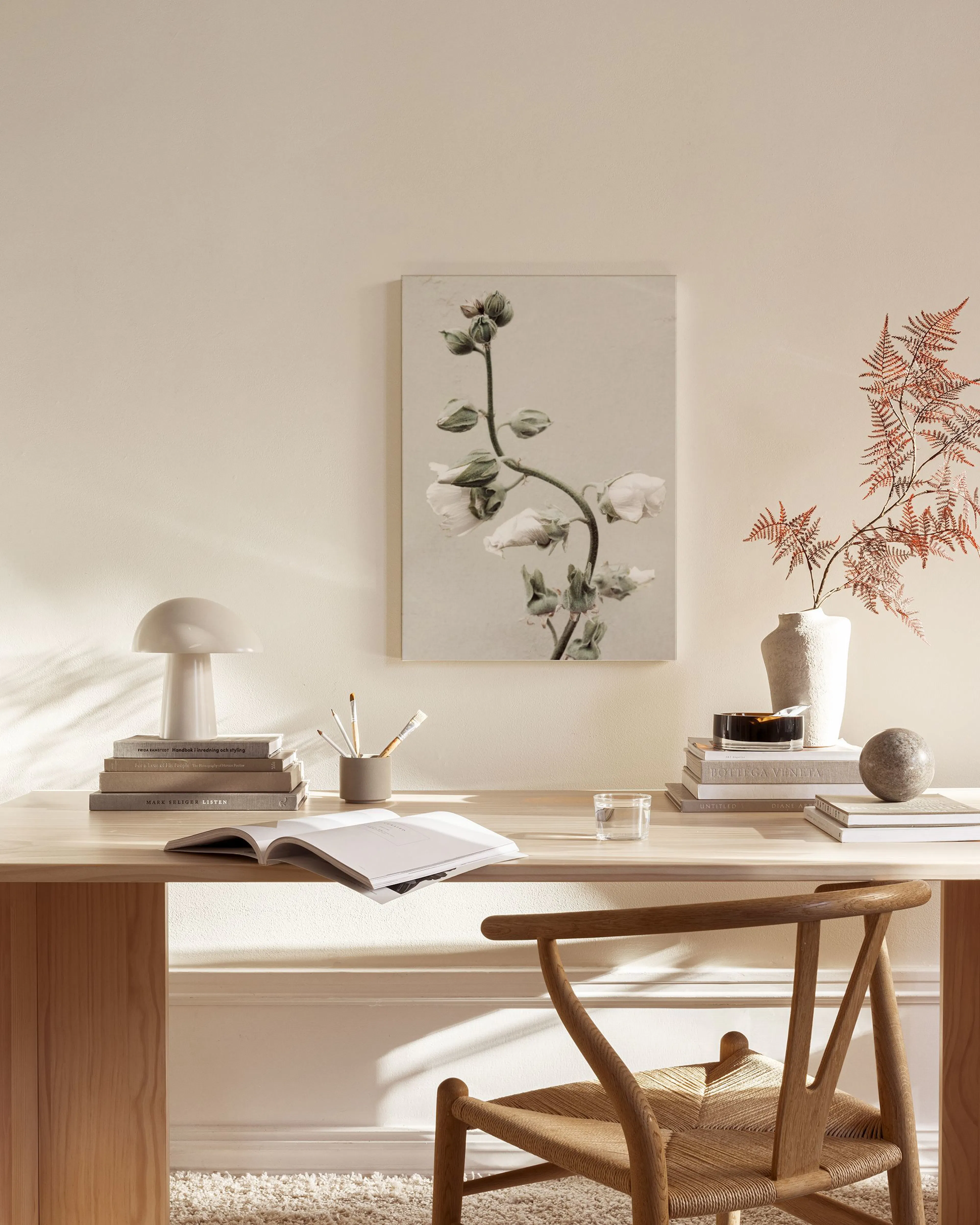 Leinwandbild mit weißen Blüten und Knospen auf beigem Hintergrund, hängt in einem modernen Wohnzimmer über einem Sideboard.
