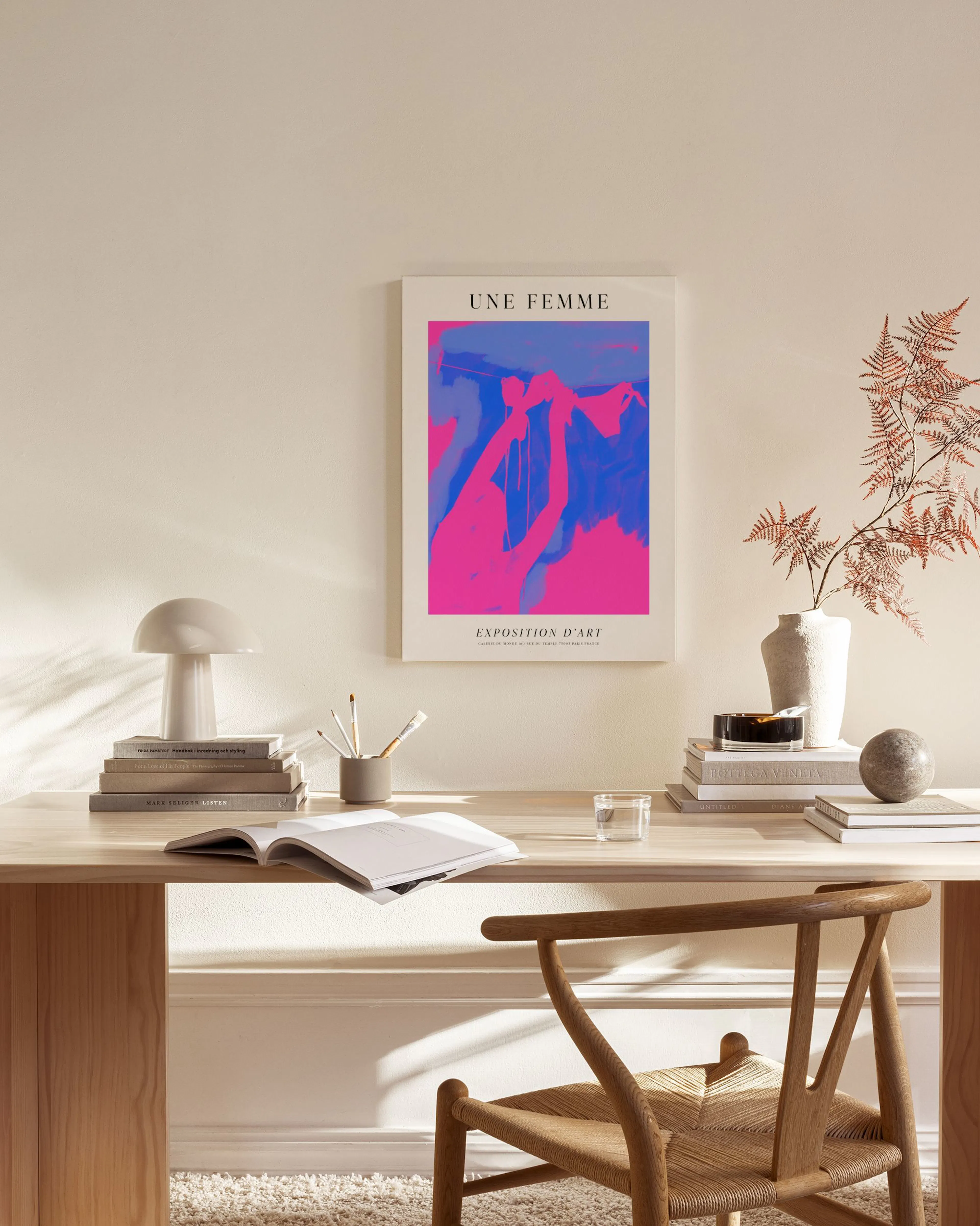 Toile Une Femme avec des formes abstraites roses et bleues, affichée dans un salon moderne au-dessus dune table basse.
