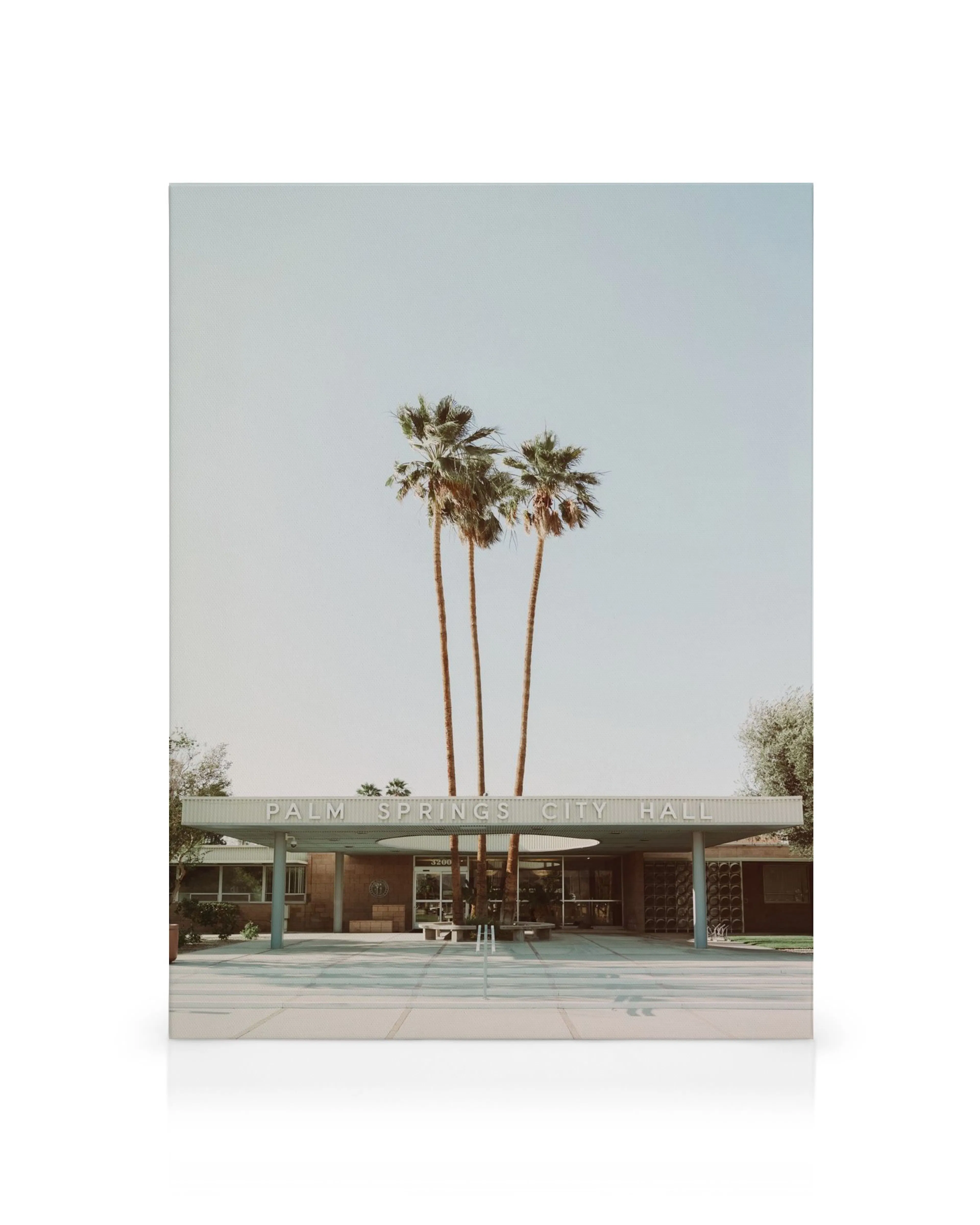 Obraz na plátne: Palm Springs City Hall s palmami a modernistickou architektúrou pod modrou oblohou.