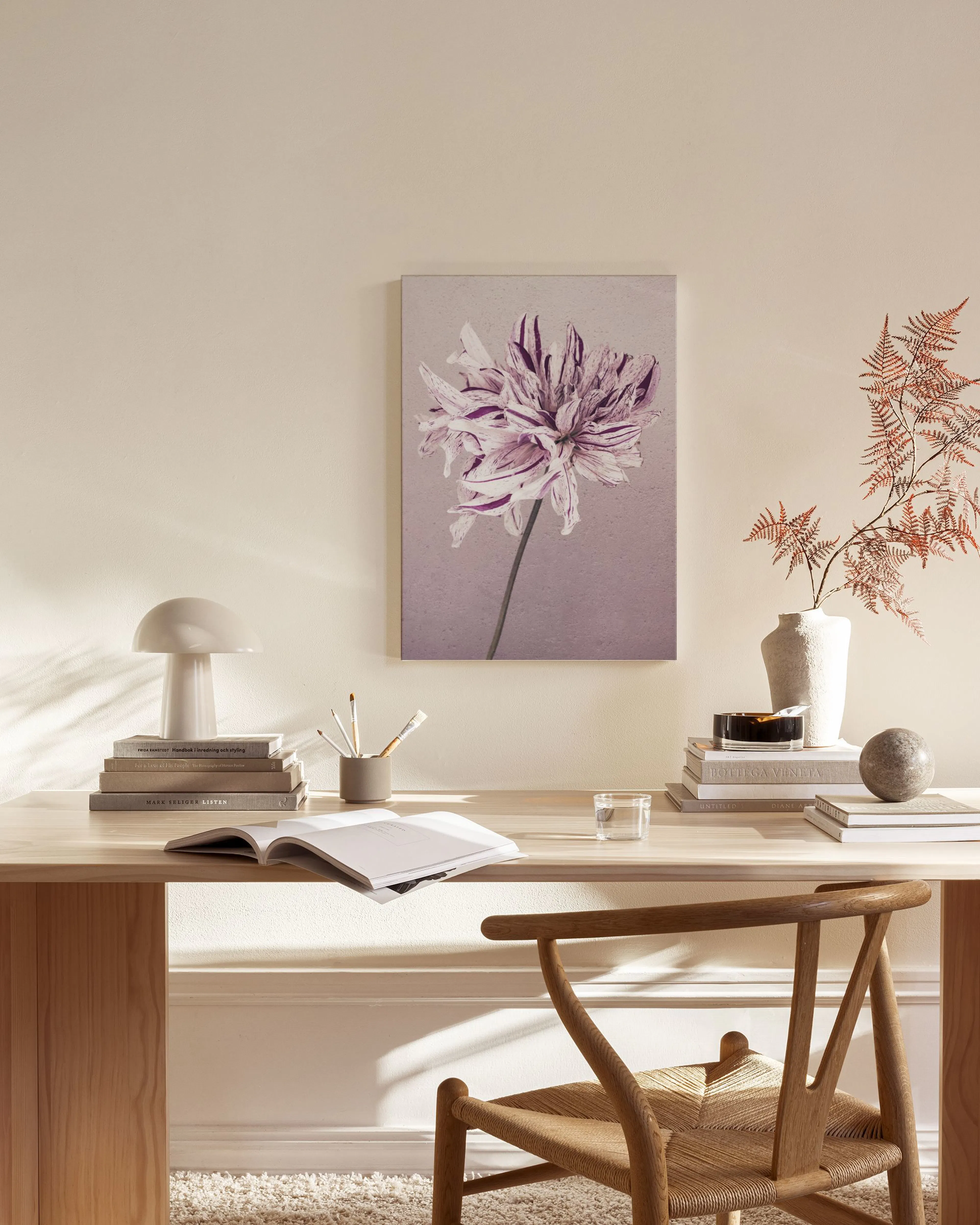 Leinwandbild einer lila Blüte auf violettem Hintergrund, über einem Sideboard in einem Wohnzimmer.