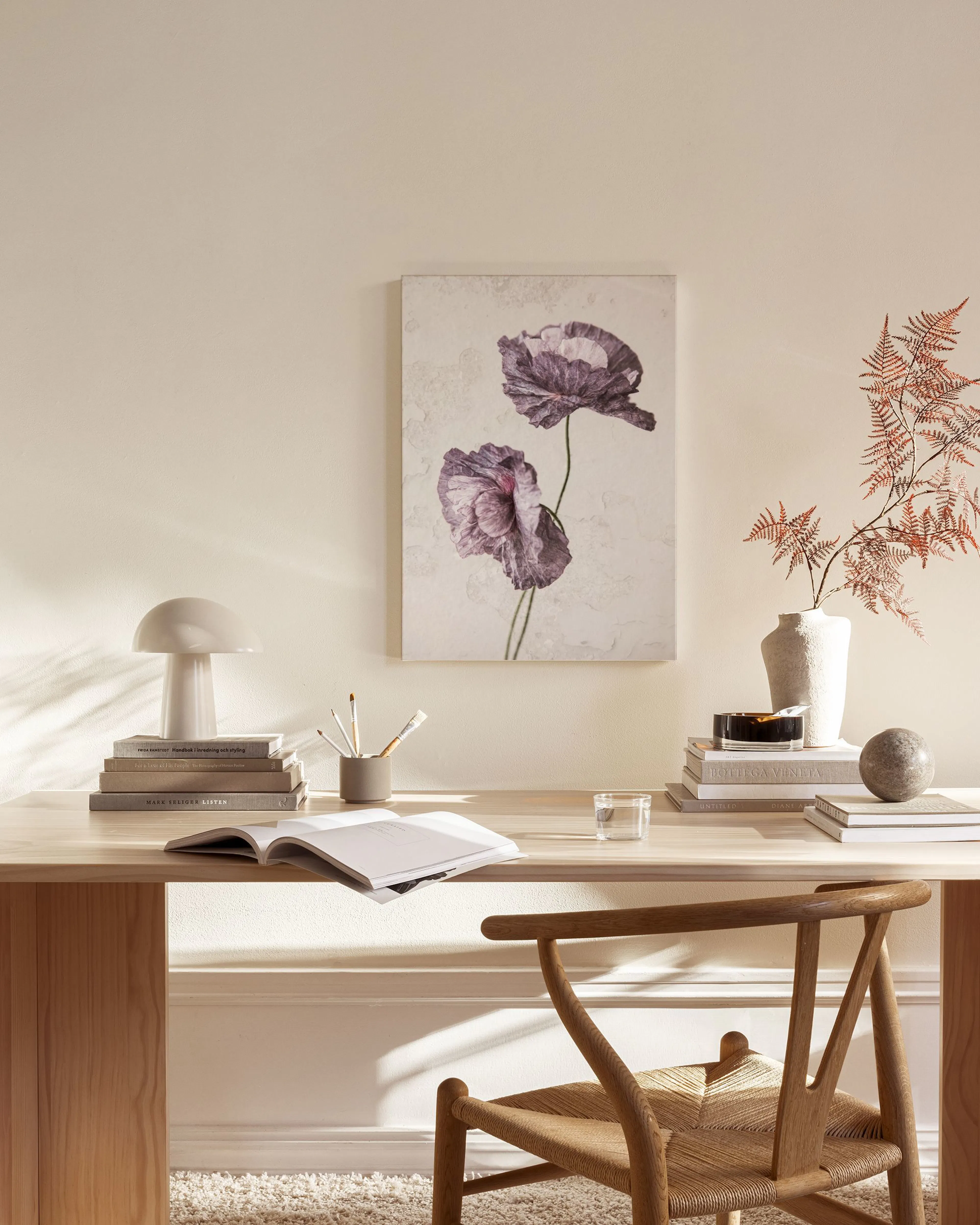 Canvastavla med två lila vallmoblommor i ett ljust vardagsrum med trädetaljer.