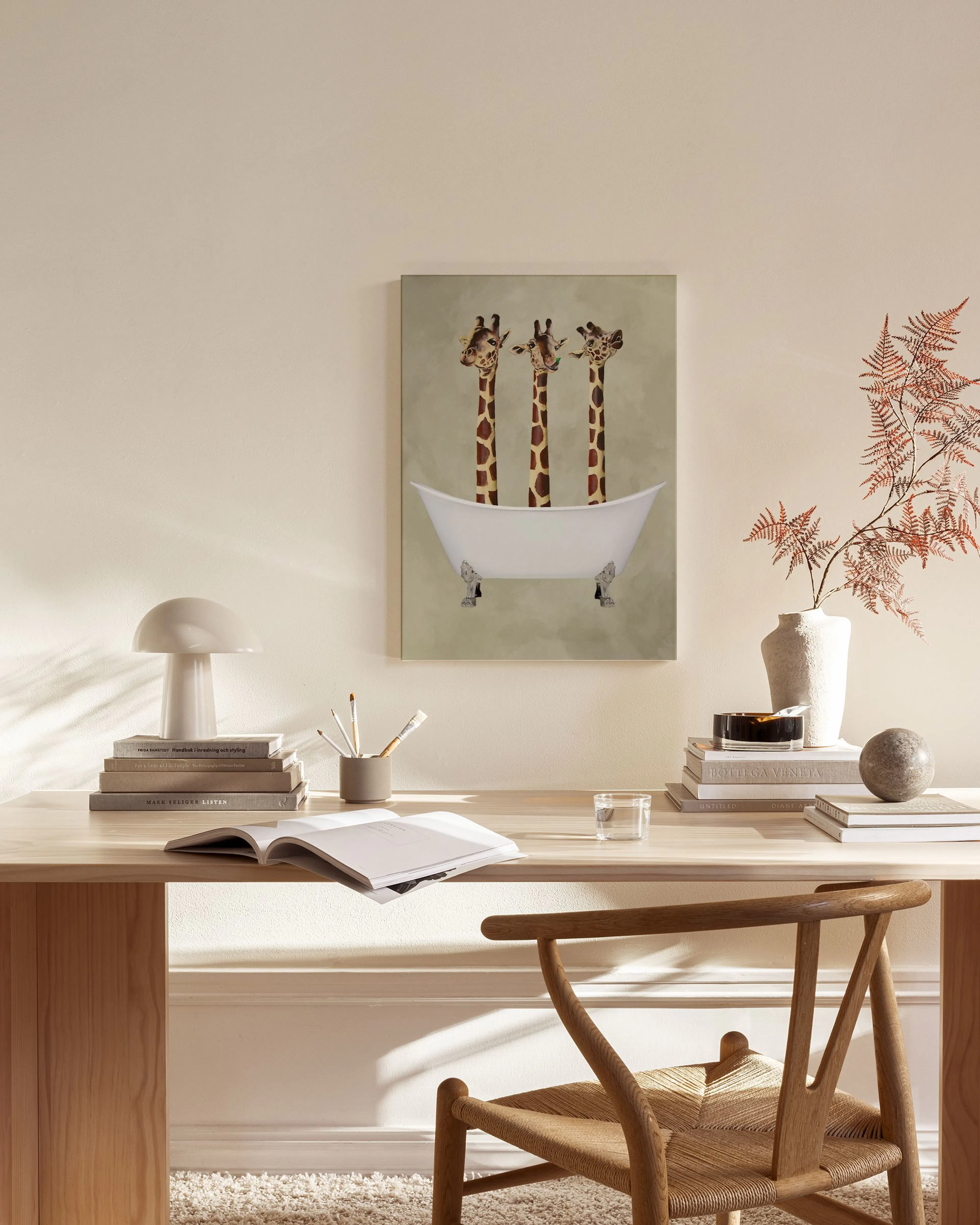 Leinwandbild mit drei Giraffen in einer Badewanne, hängt über einem Holzregal im Wohnzimmer.