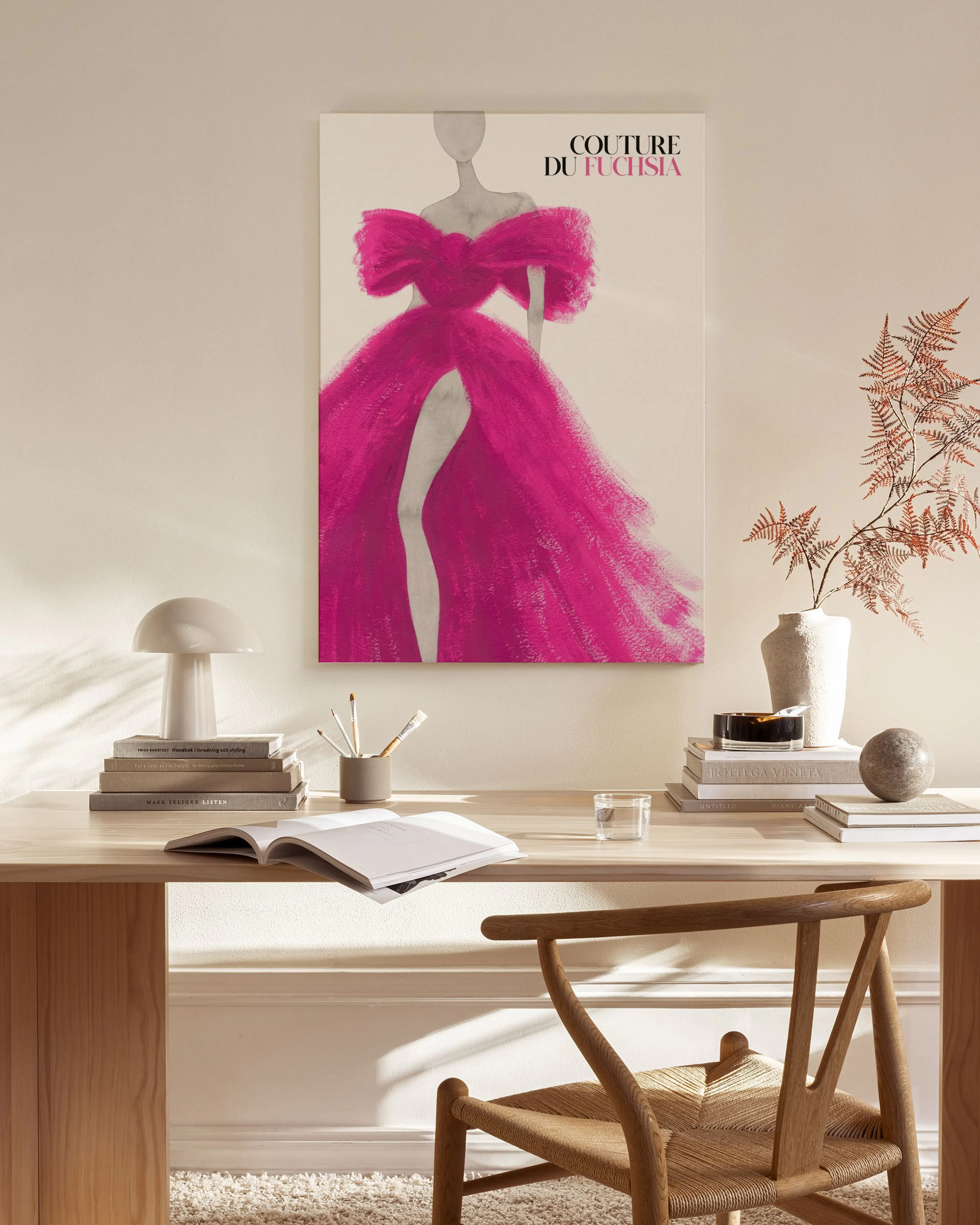 A fashion art print of a figure in a vibrant fuchsia gown, titled COUTURE DU FUCHSIA, displayed in a modern living room.