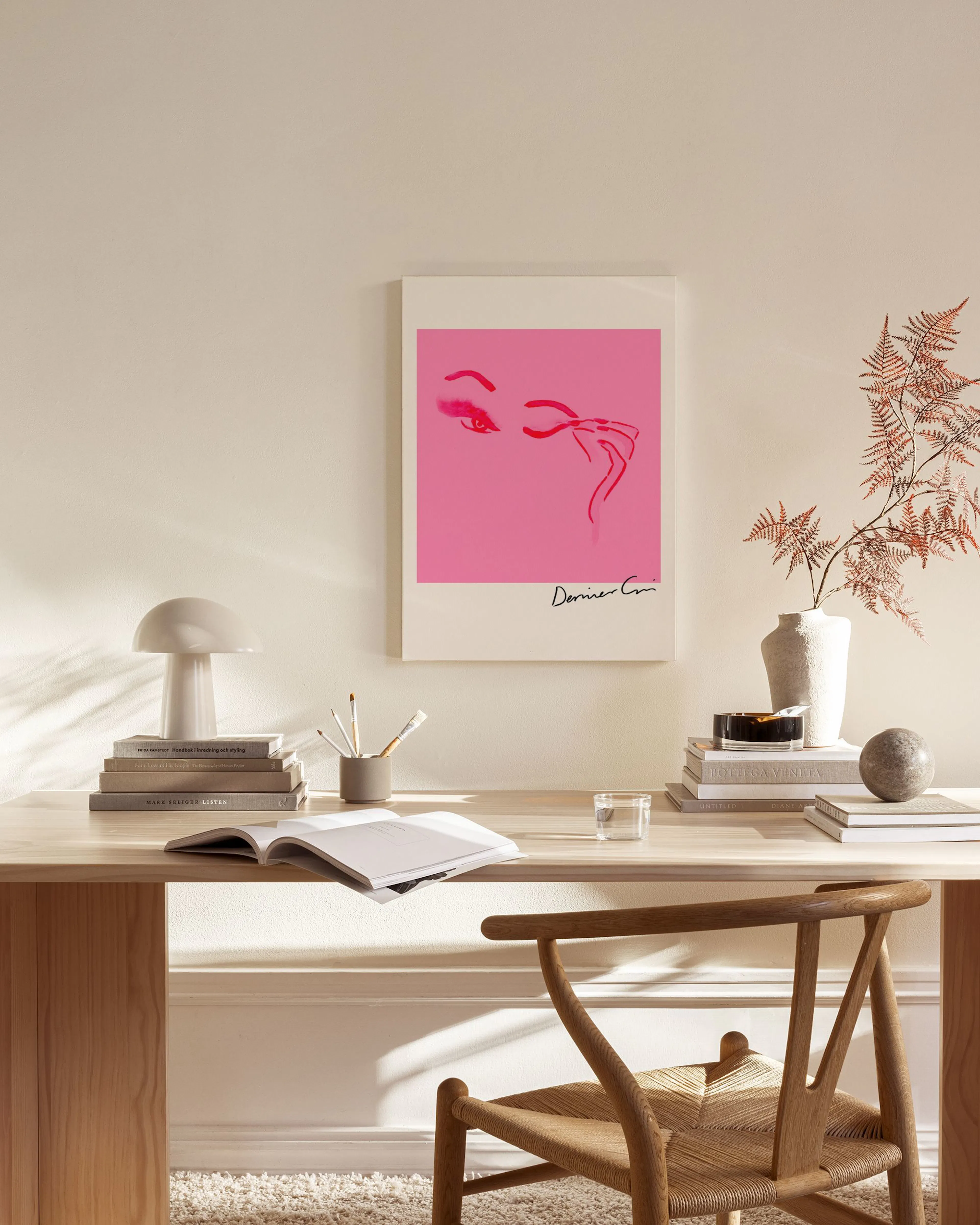 Canvas met roze achtergrond en rode contouren van ogen en een hand, hangend in een neutrale woonkamer.
