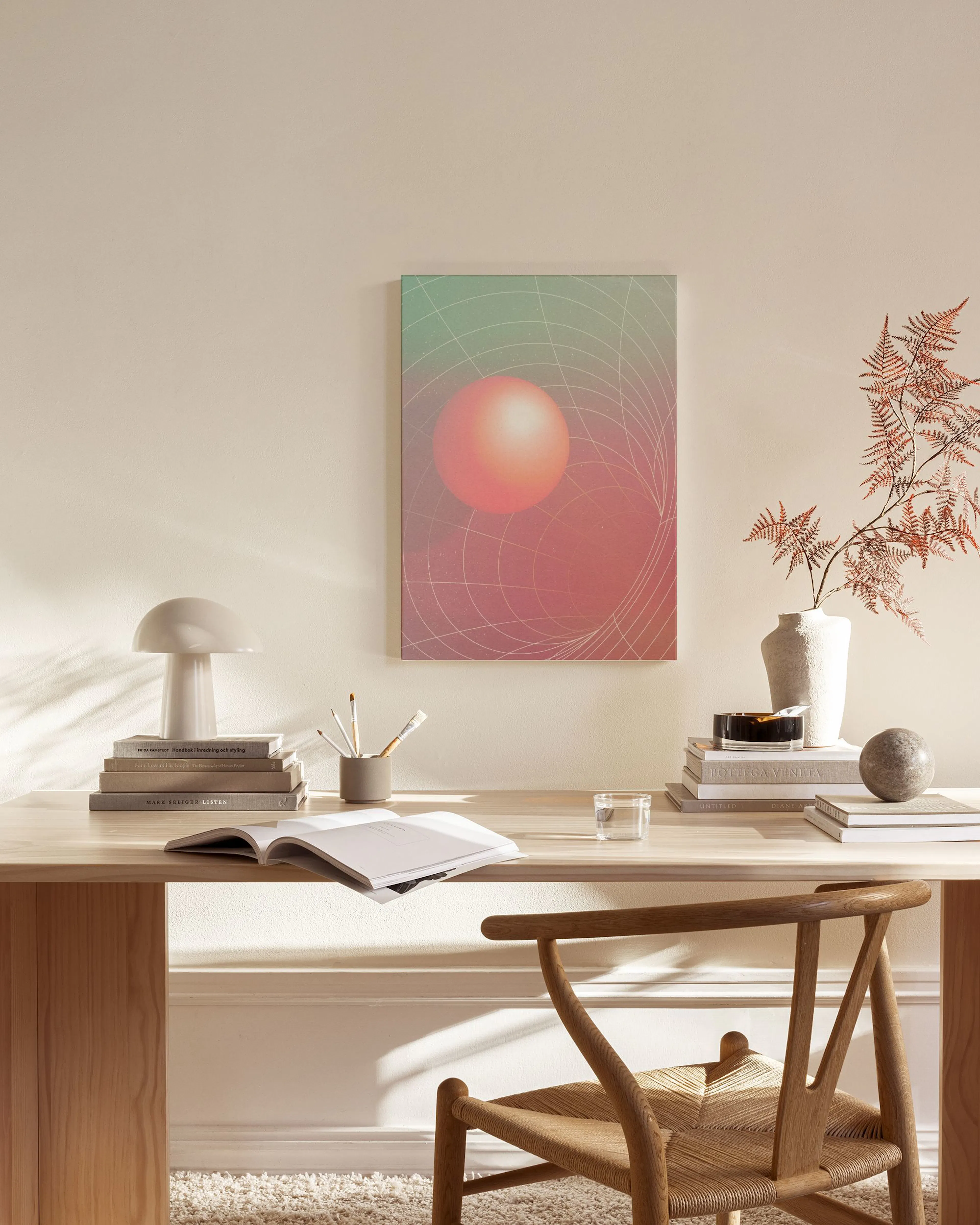 Gradient sphere print with a red sphere on a green and red background with white grid lines, hanging in a minimalist living room