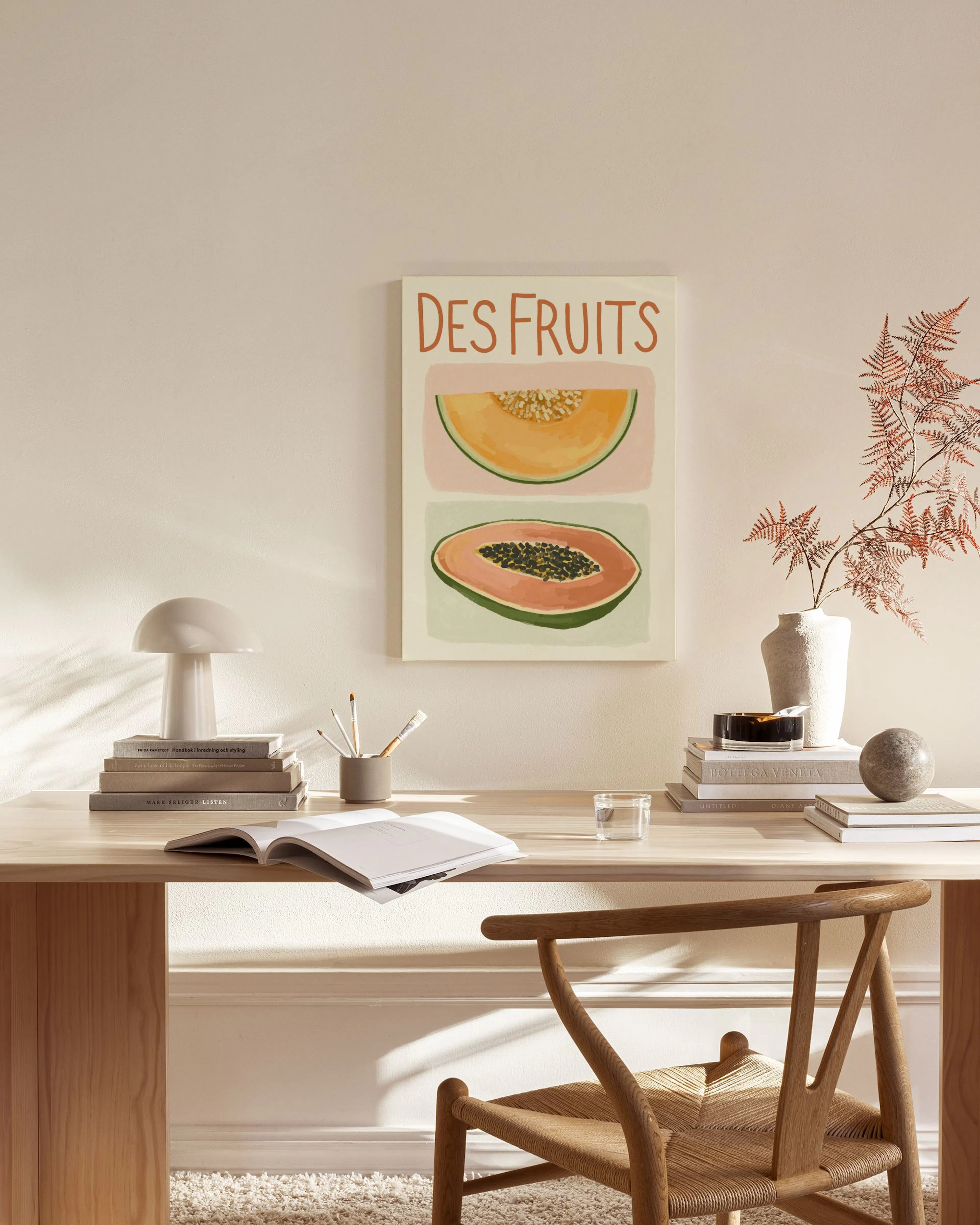 Lienzo con diseño de melón y papaya, y el texto DES FRUITS, colgado en una sala de estar moderna.