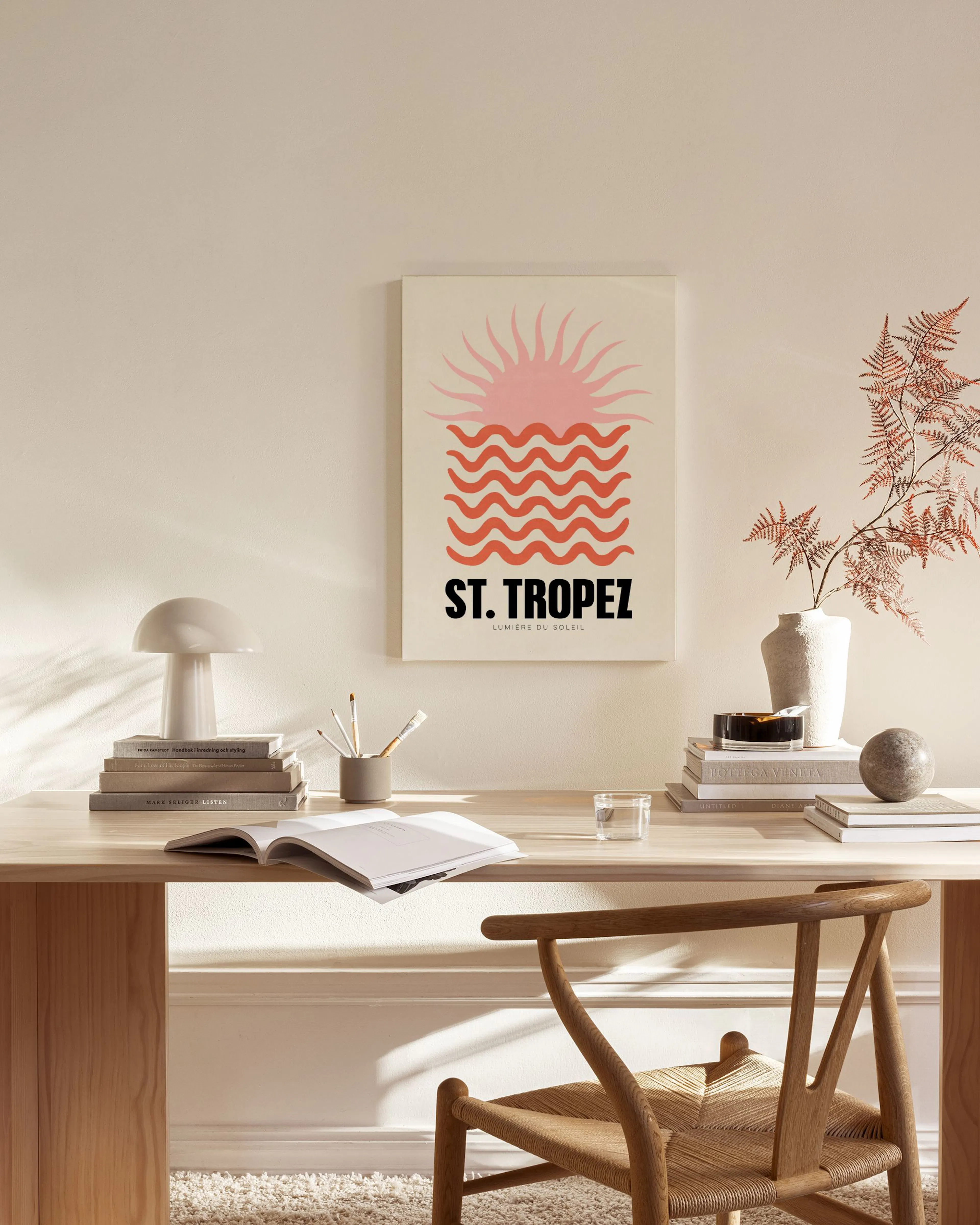 Stampa su tela St. Tropez con sole rosa e onde arancioni, esposta in un soggiorno moderno.