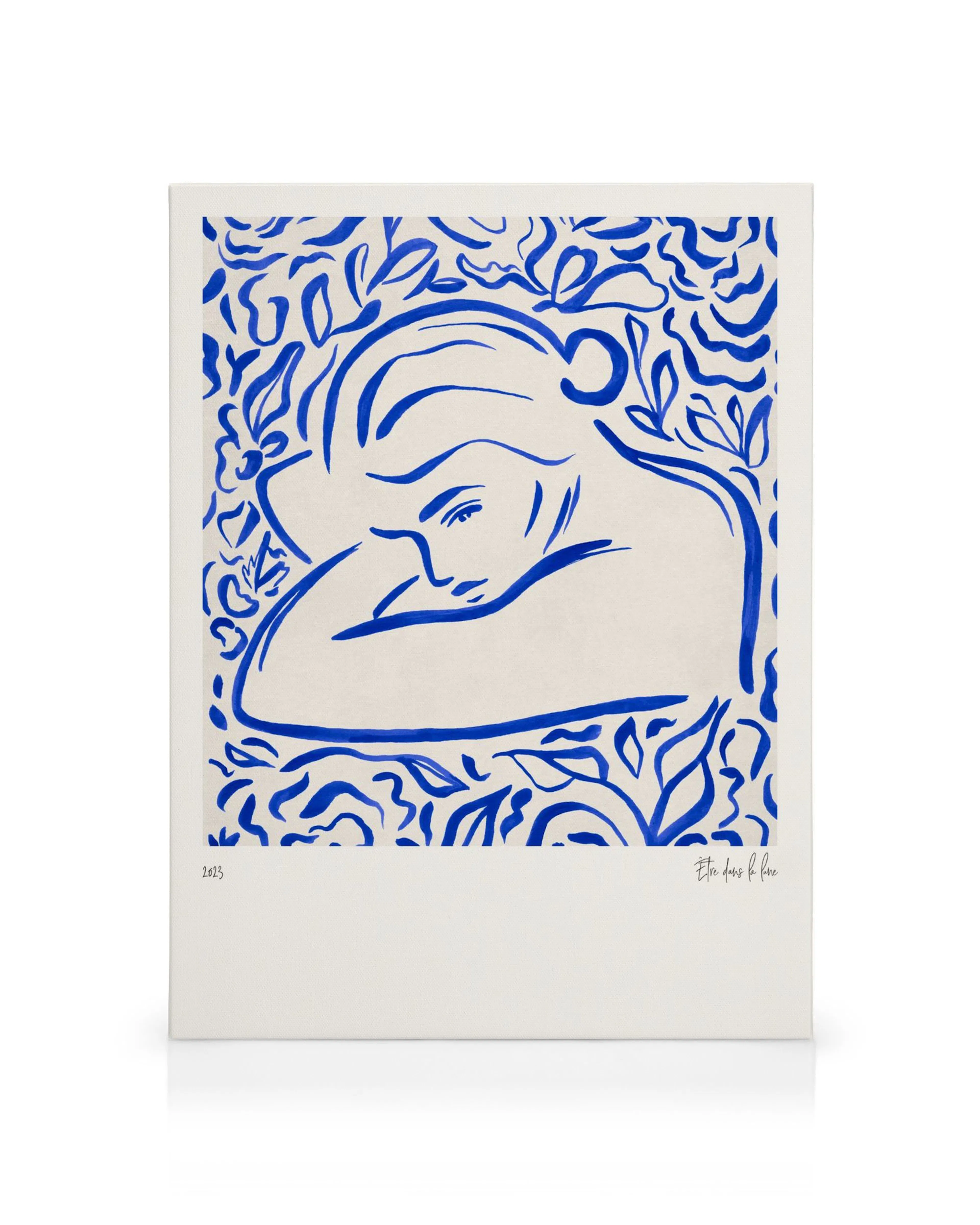 Abstract blue and white canvas print featuring a figure resting amidst leafy patterns, creating a peaceful gallery wall.