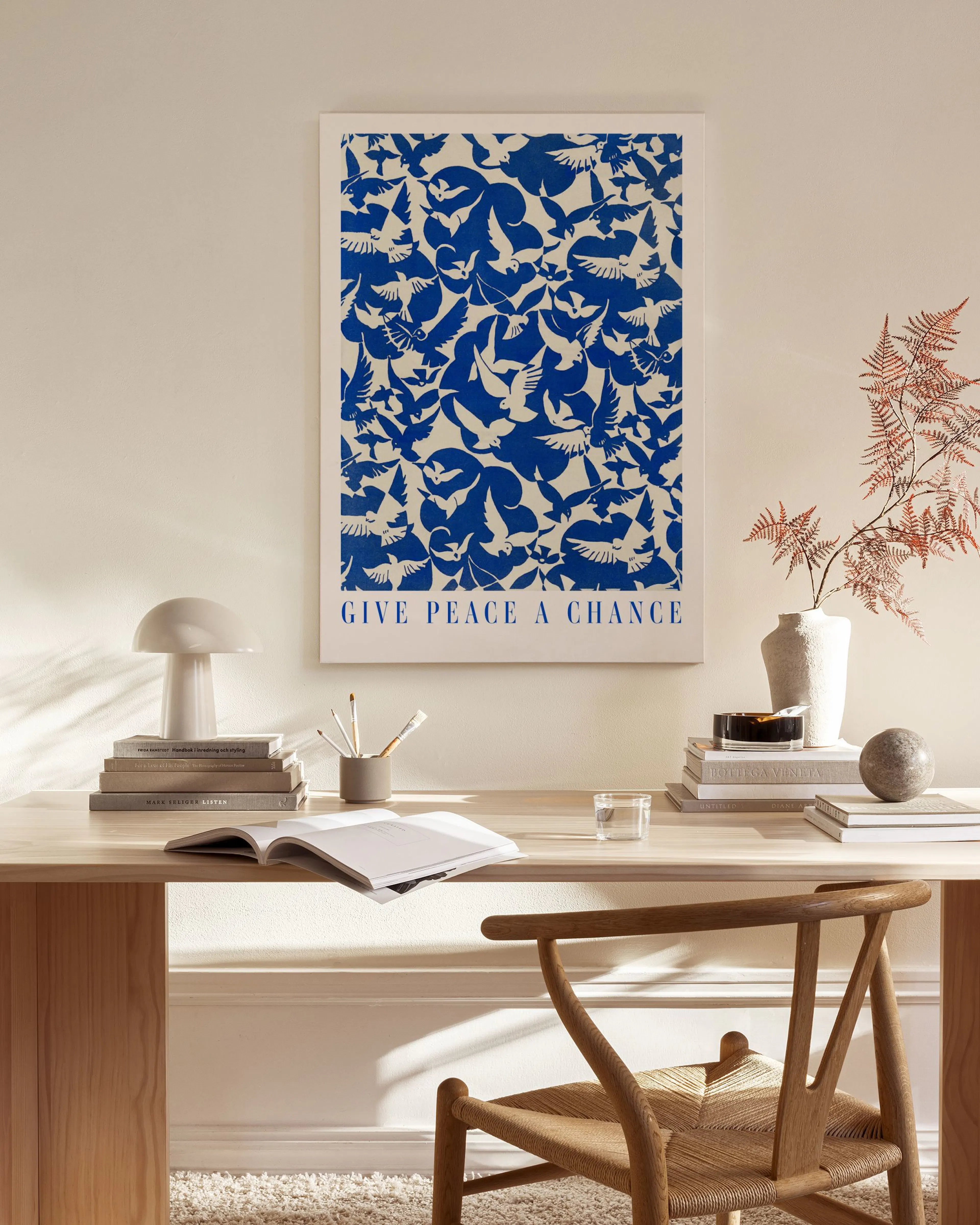 Toile Give Peace a Chance avec motifs doiseaux bleus, affichée dans un salon moderne et lumineux.