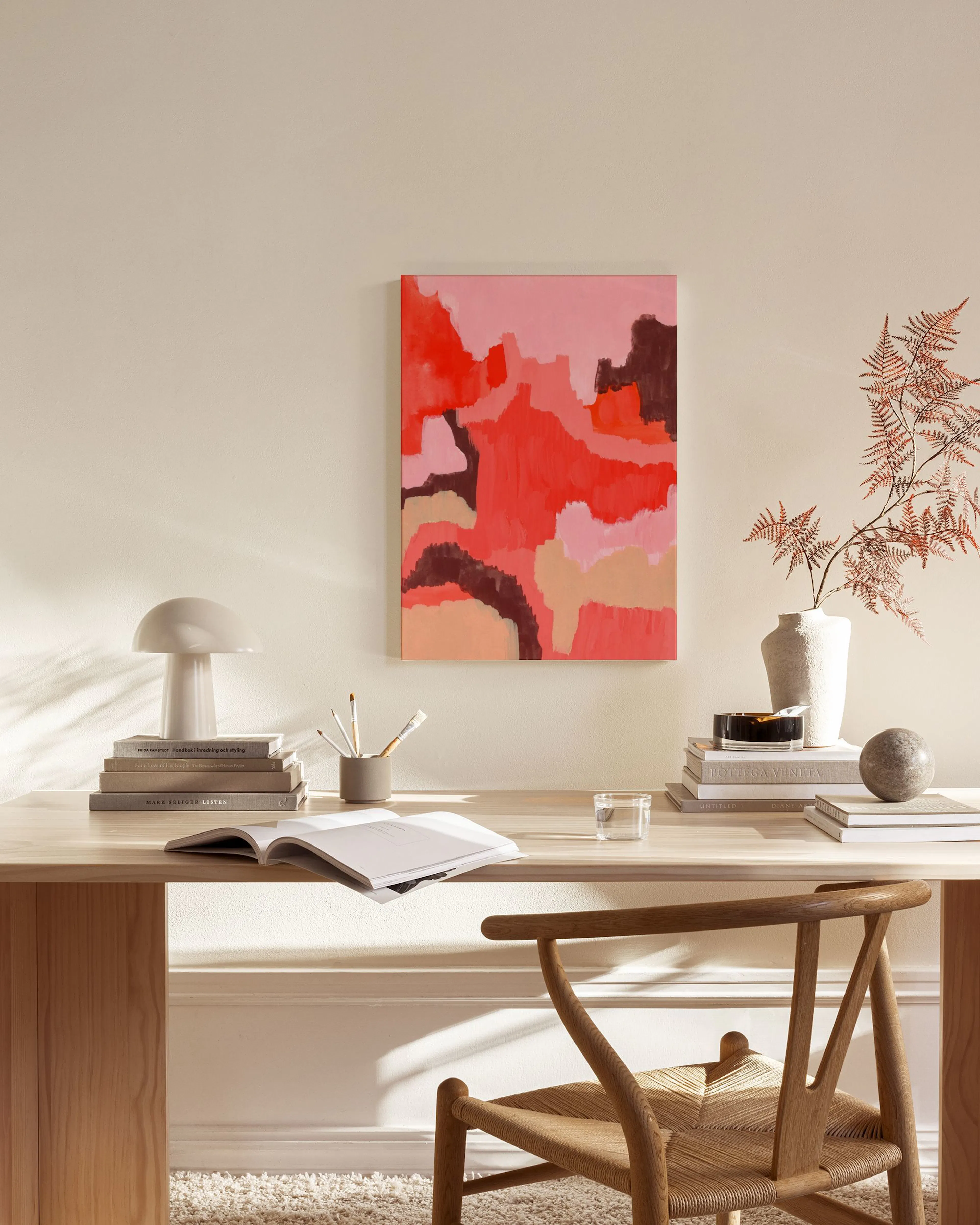 Abstract canvas print with red, pink, and brown organic shapes, displayed above a wooden console in a modern living room.