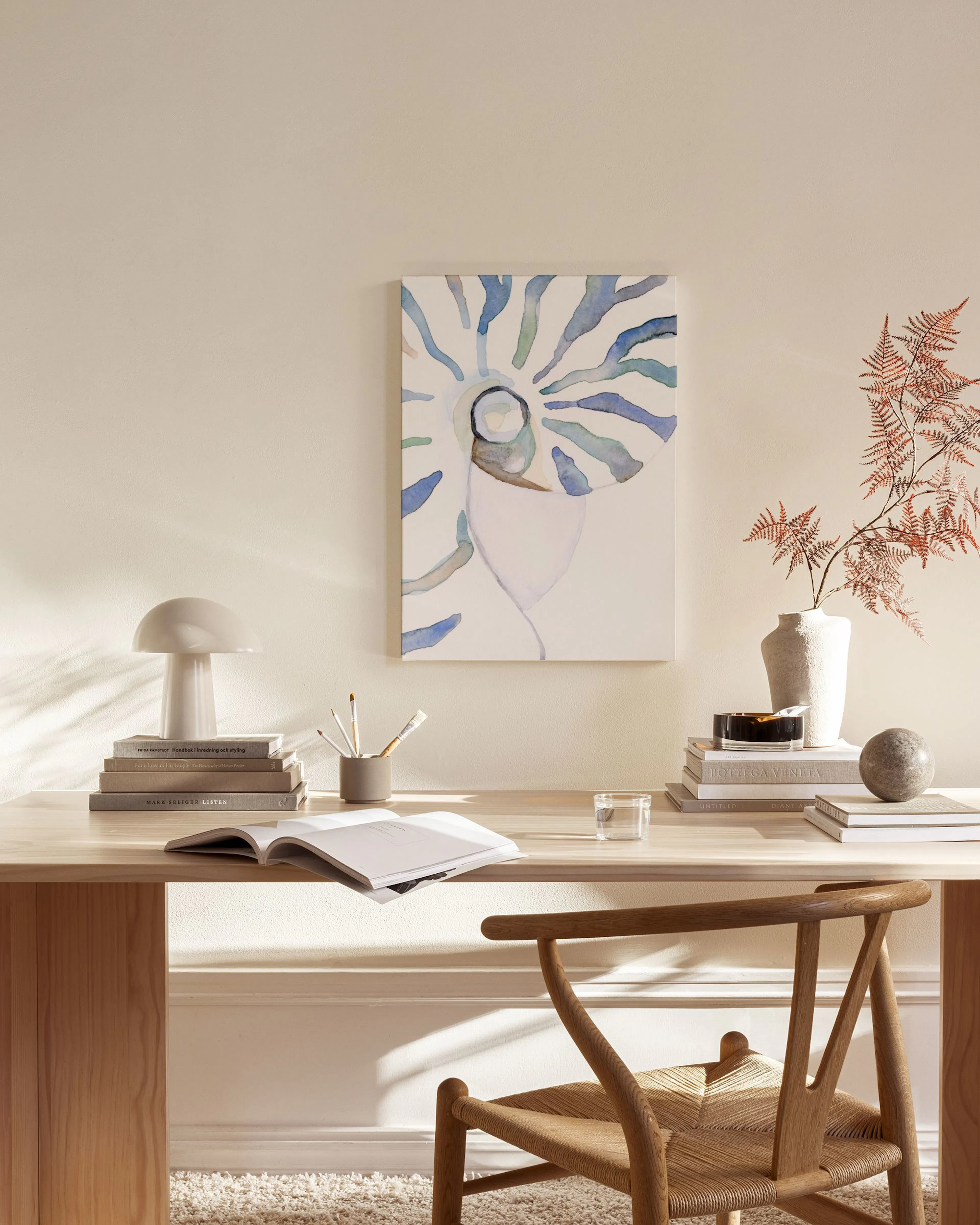 Toile coquillage stylisé aux tons bleus et verts, suspendue au-dessus dun banc en bois clair dans un salon beige.