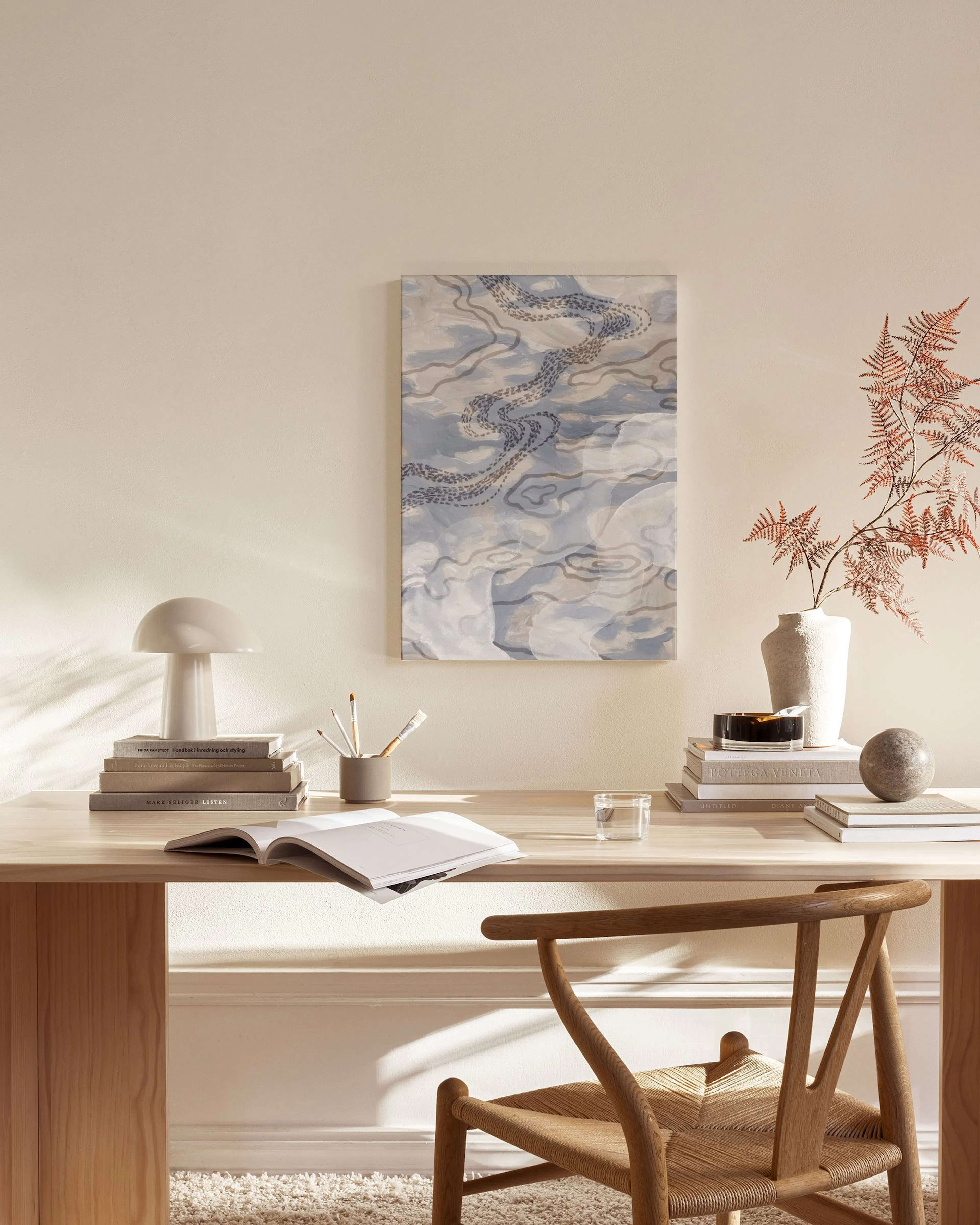 Toile abstraite bleu pâle avec motifs ondulés gris, suspendue dans un salon moderne aux tons neutres.