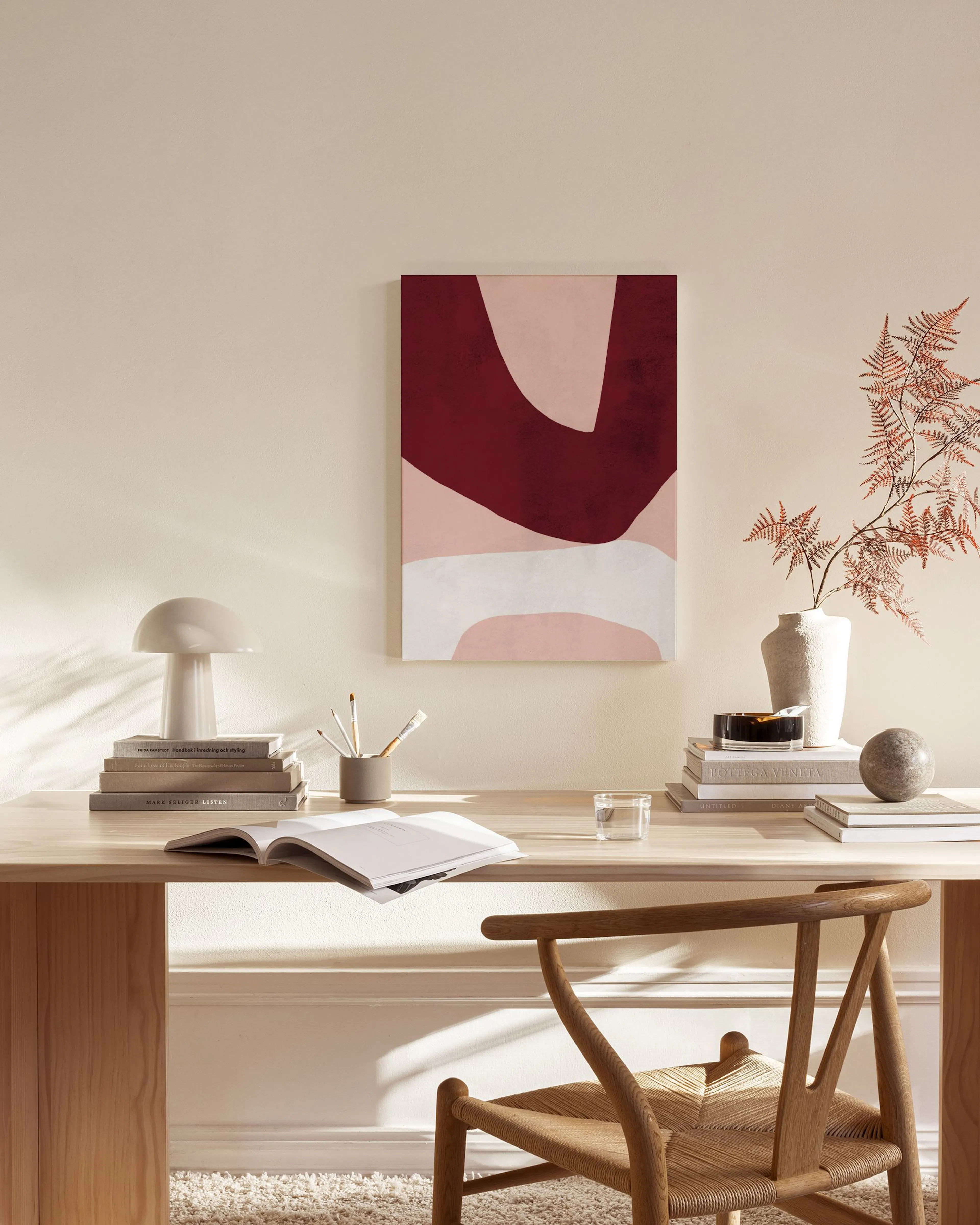 Abstraktes Leinwandbild mit burgunderroten, rosa und weißen organischen Formen, hängend in einem modernen Wohnzimmer.