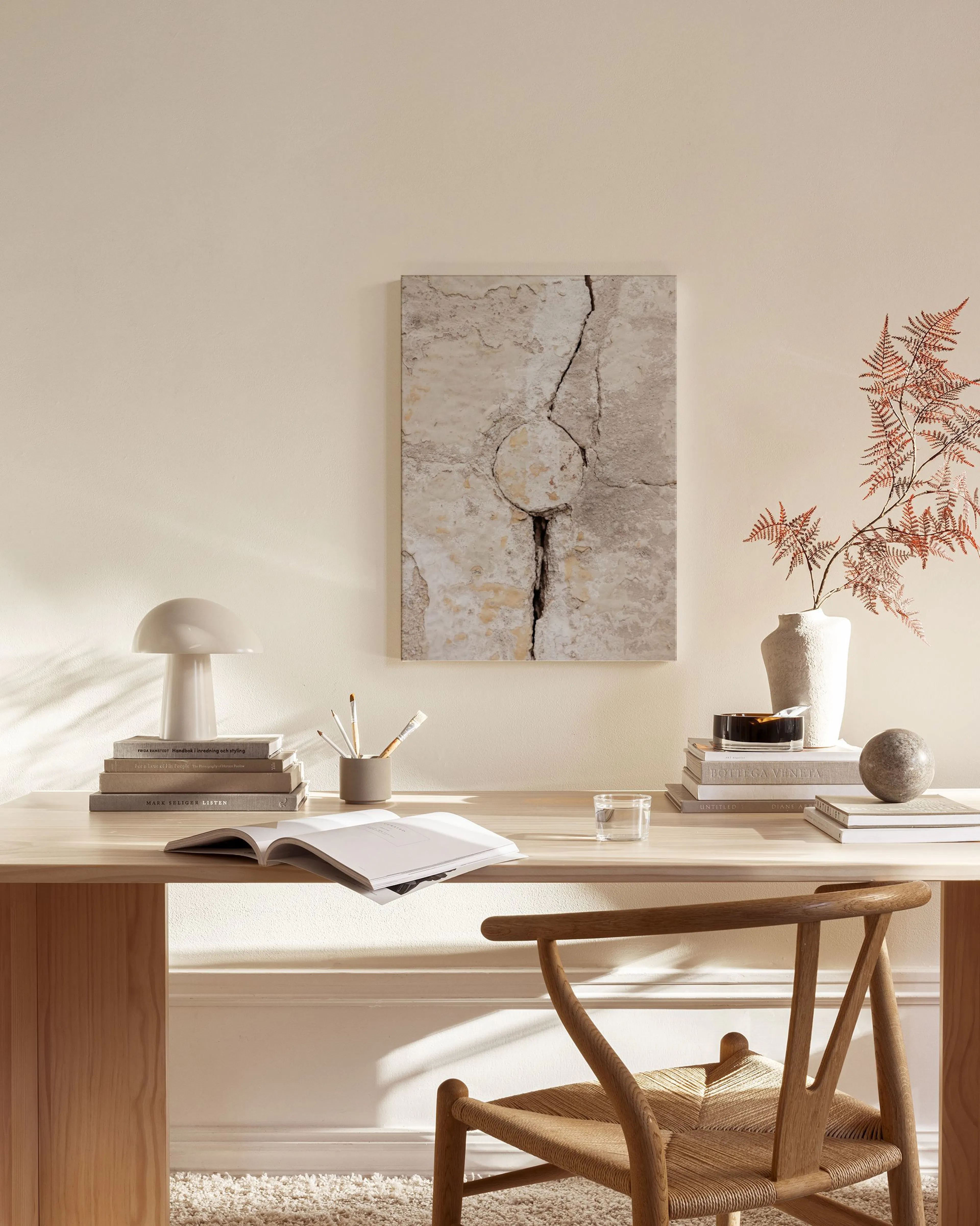 Lienzo con textura de pared agrietada en tonos beige y gris, colgado sobre un mueble de madera en una sala de estar.