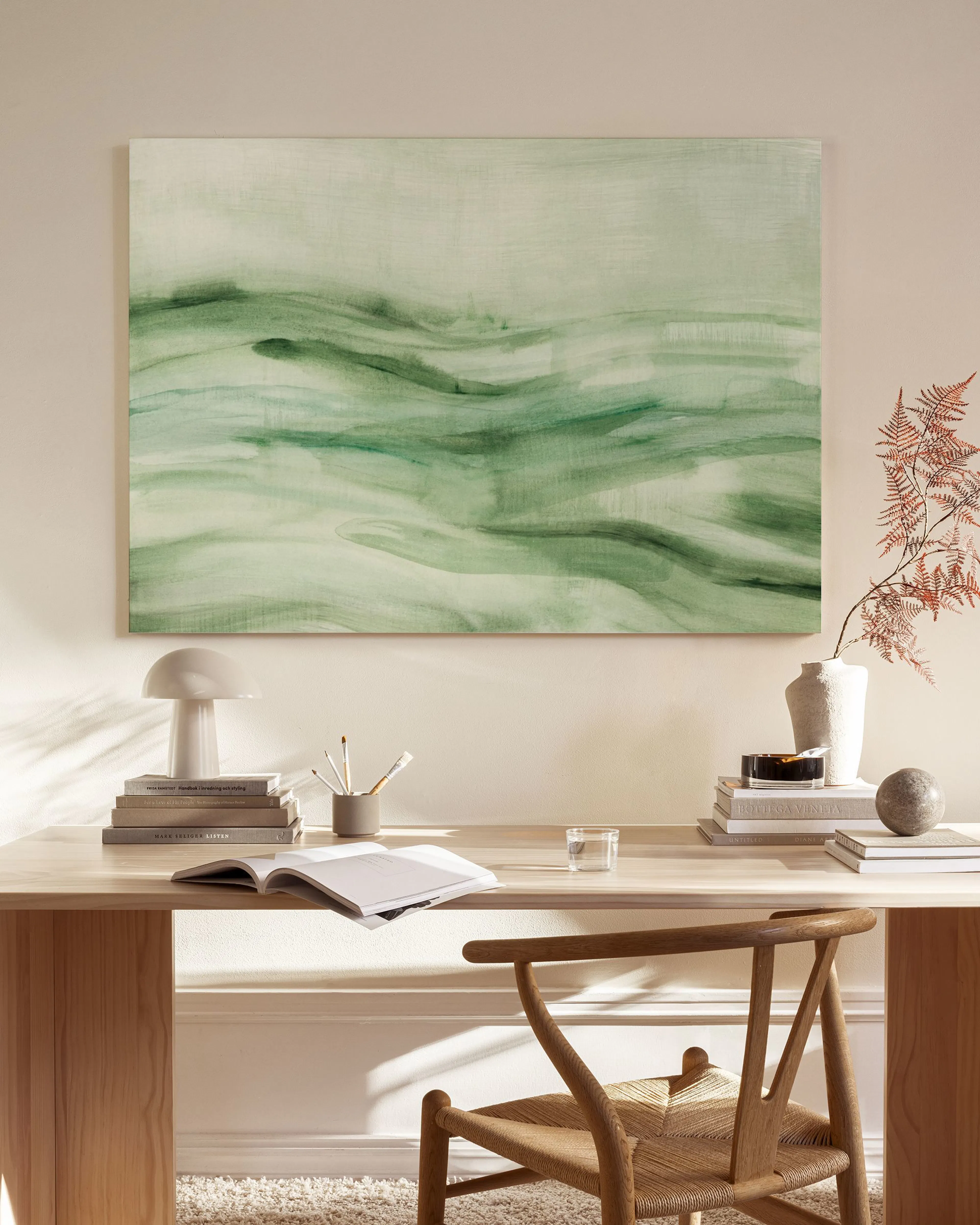Canvas met een abstract groen landschap met golvende lijnen, hangend in een neutrale woonkamer boven een houten dressoir.