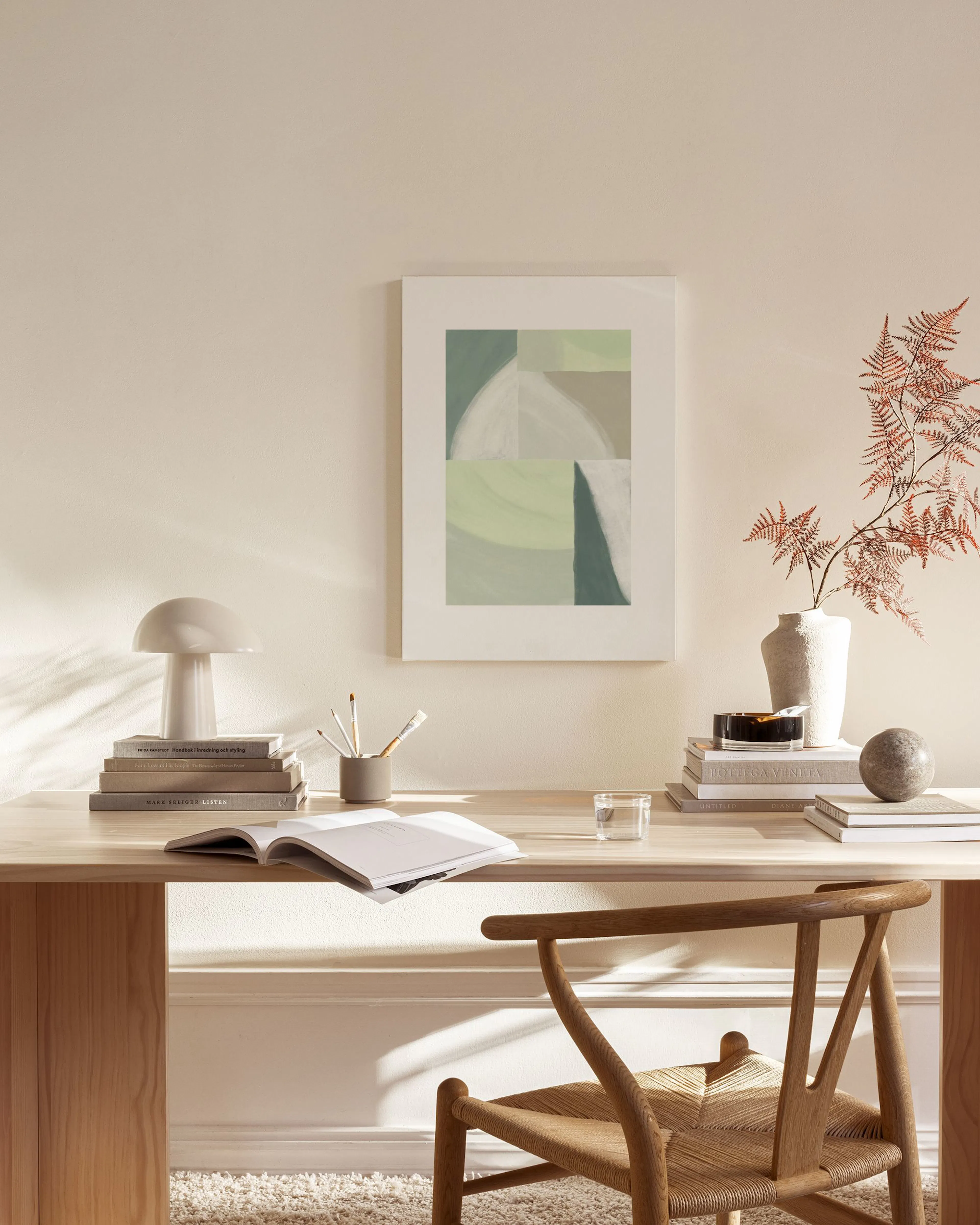 Leinwandbild mit organischen Formen in Grün, Beige und Weiß, hängend über einem Sideboard im Wohnzimmer.