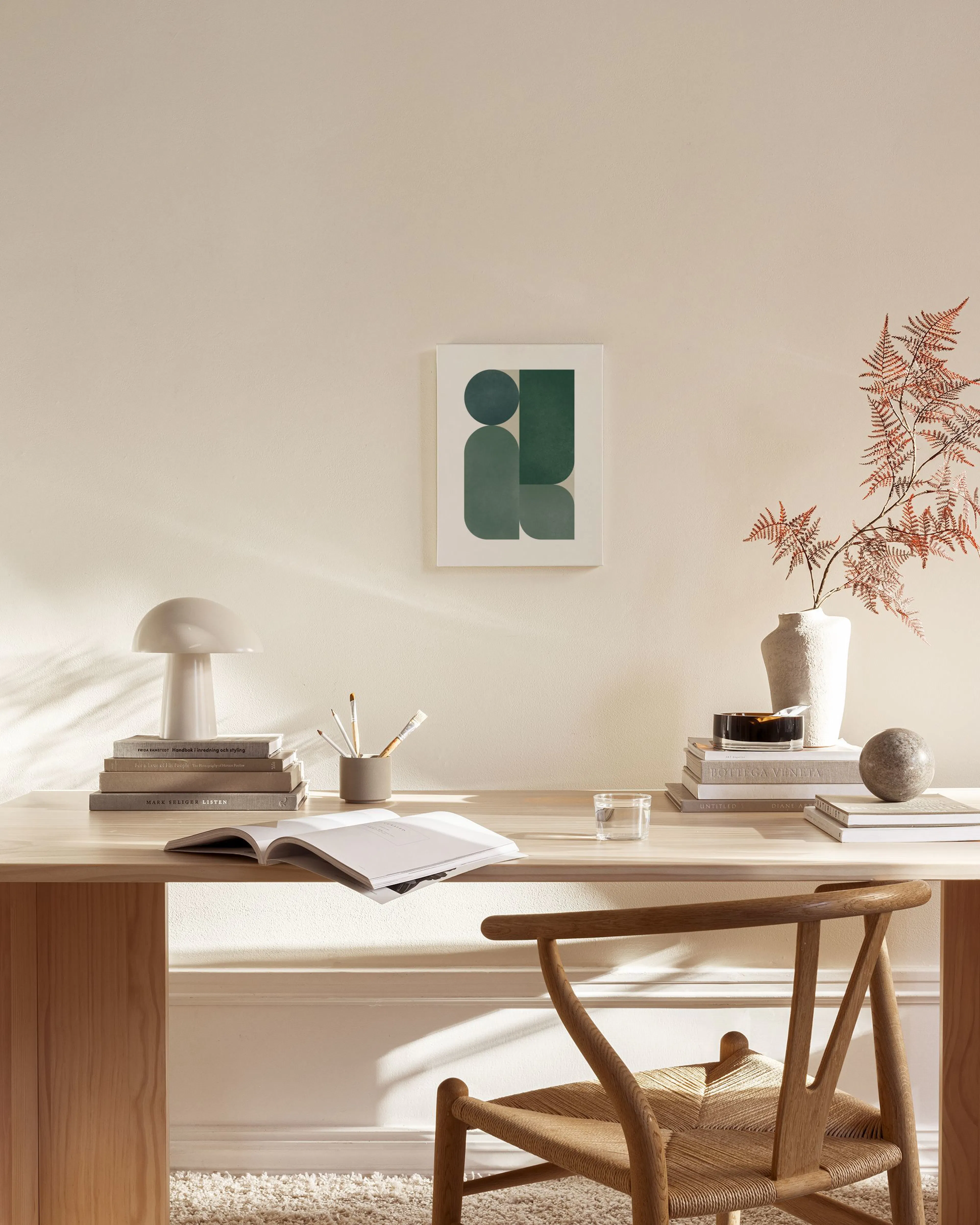 Leinwandbild mit dunkel- und hellgrünen geometrischen Formen und Halbkreisen, hängend in einem modernen Wohnzimmer über einem Si