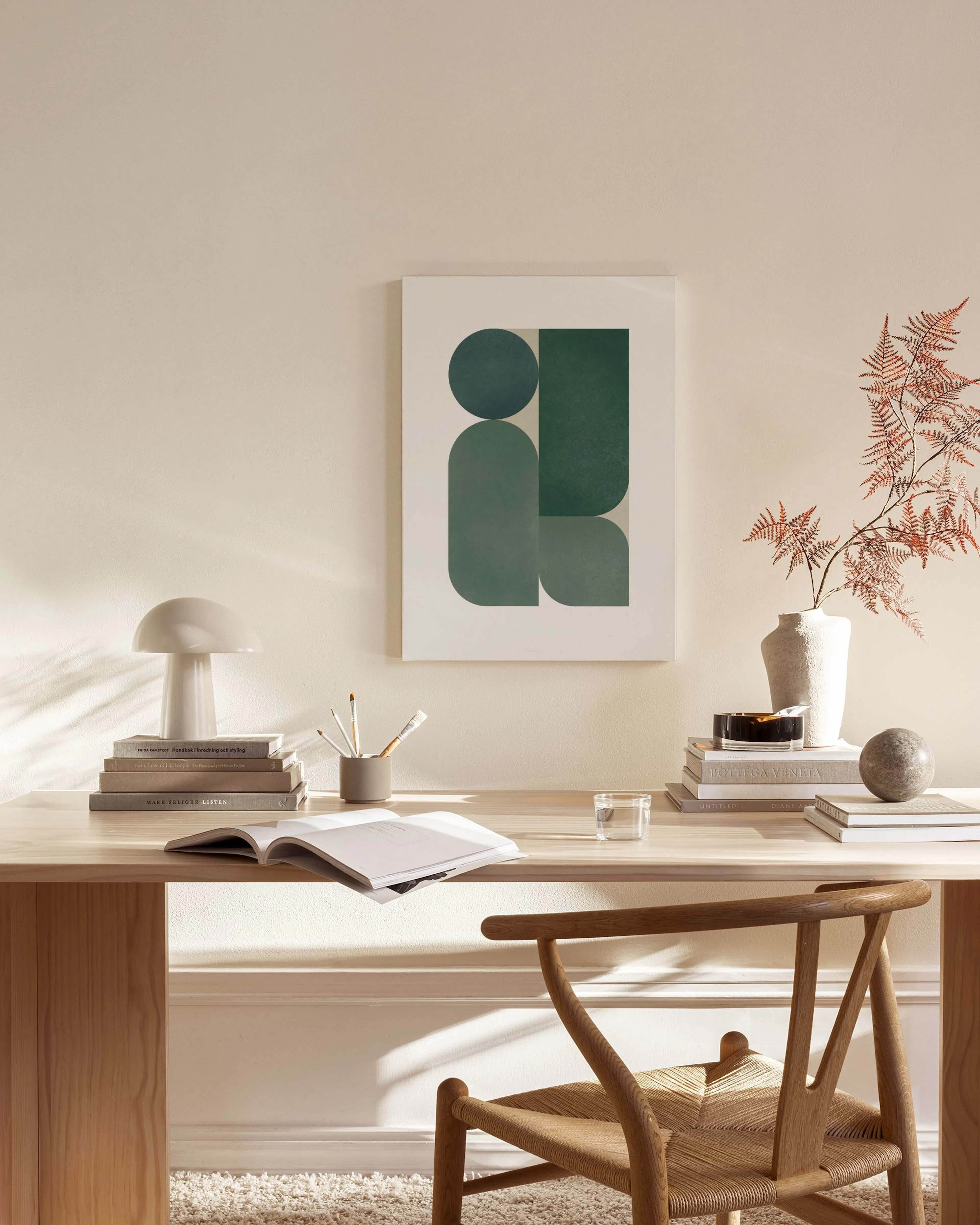 Canvastavla med gröna geometriska former och beiga inslag, hängande i ett ljust vardagsrum.