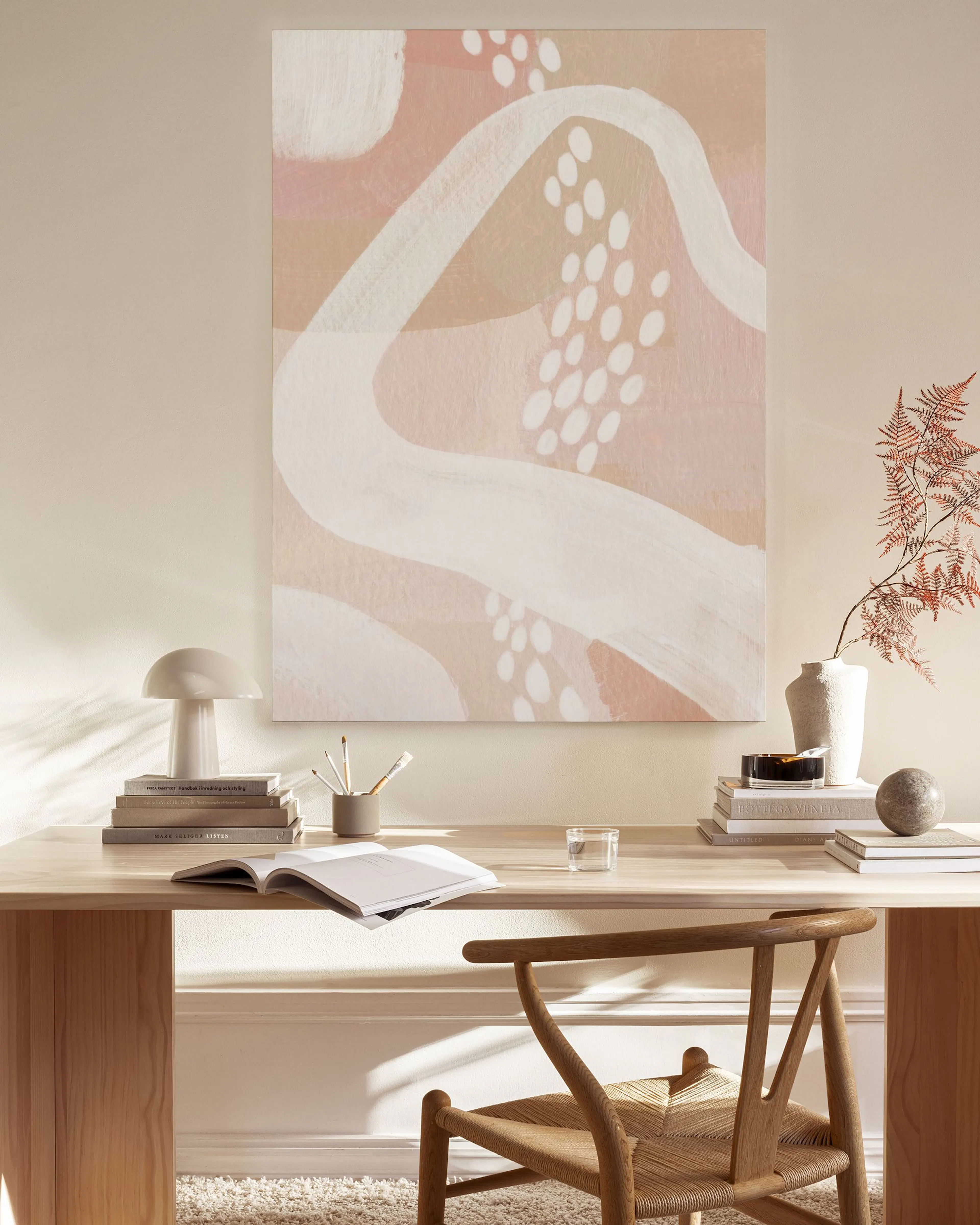 Leinwandbild mit rosa, beigen und weißen organischen Formen, hängt über einem Sideboard im Wohnzimmer.