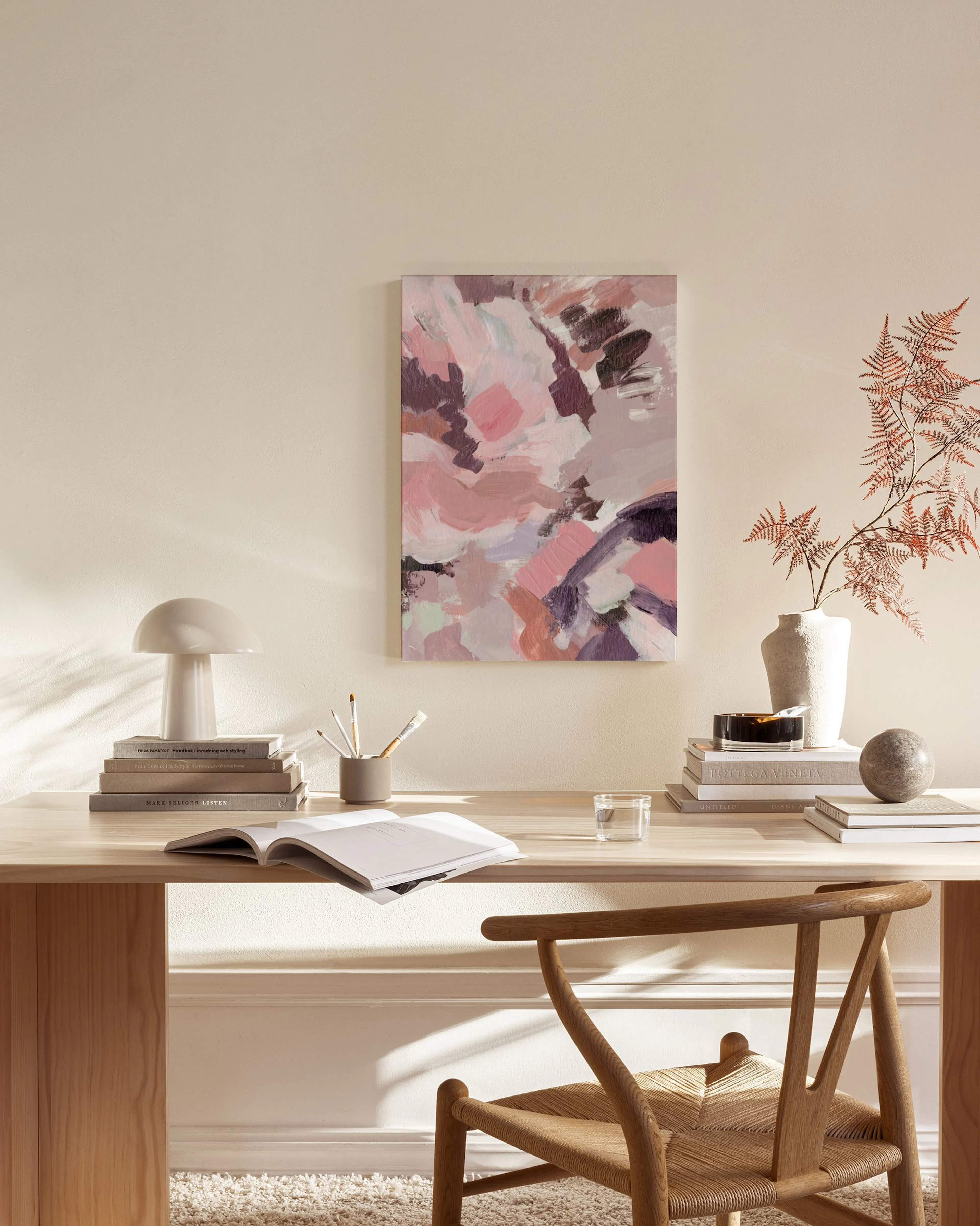 Abstract canvas print with pink, purple, and beige brushstrokes, displayed in a modern living room above a wooden console.