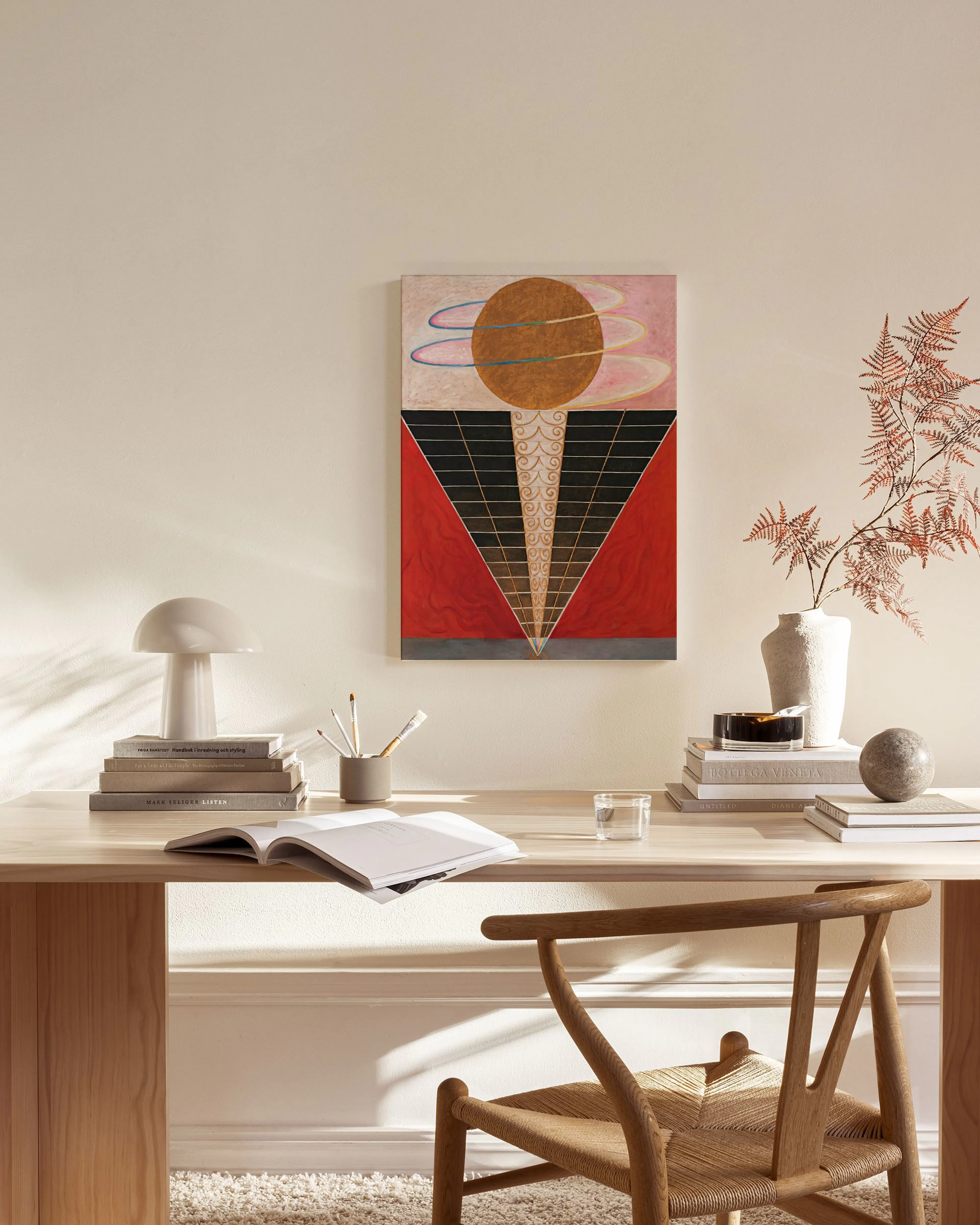 Toile abstraite avec un disque doré, des formes géométriques noires et rouges, et des volutes colorées, accrochée dans un salon 
