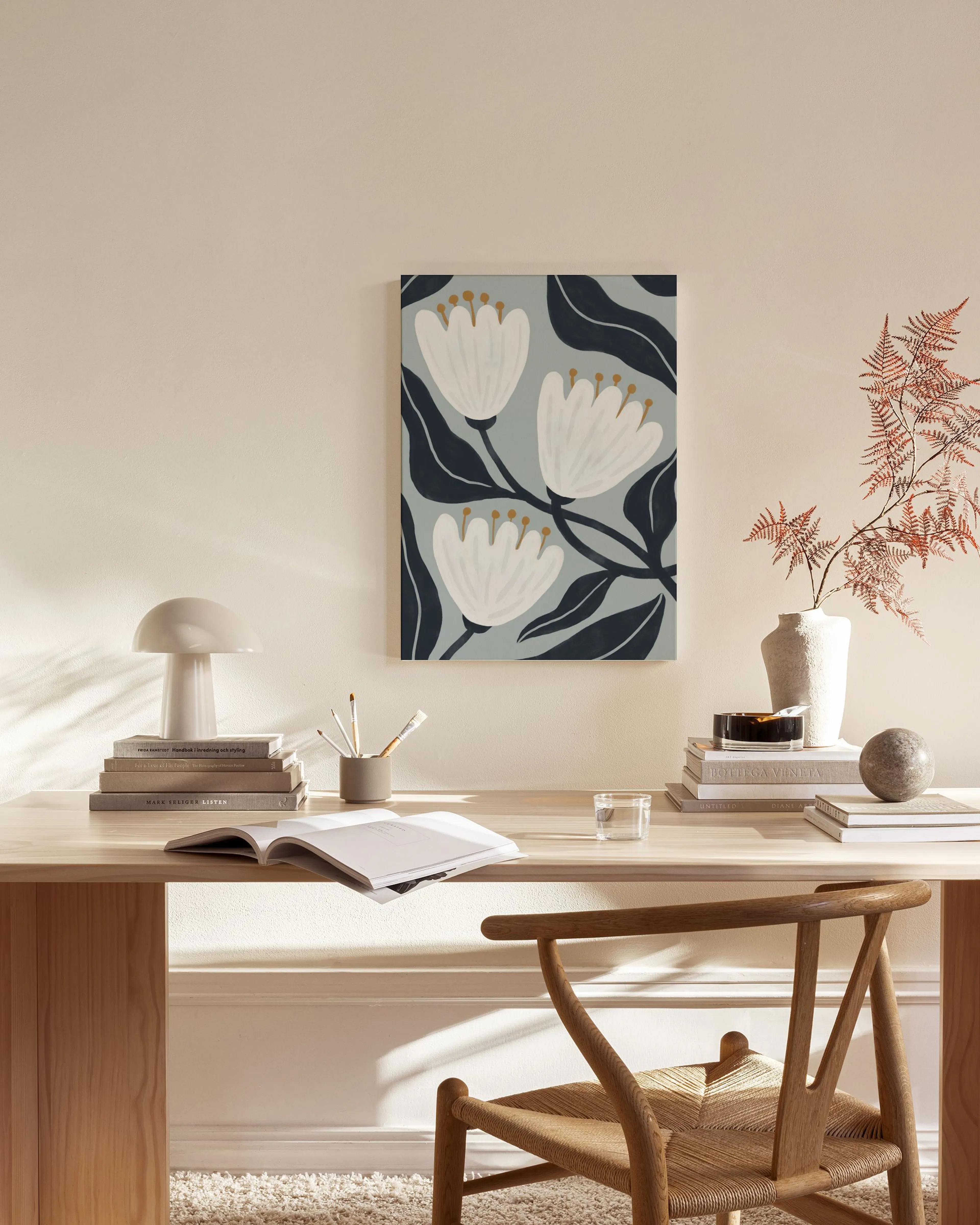 Illustratie van witte bloemen met donkerblauwe bladeren op een lichtblauwe achtergrond, hangend in een lichte woonkamer.