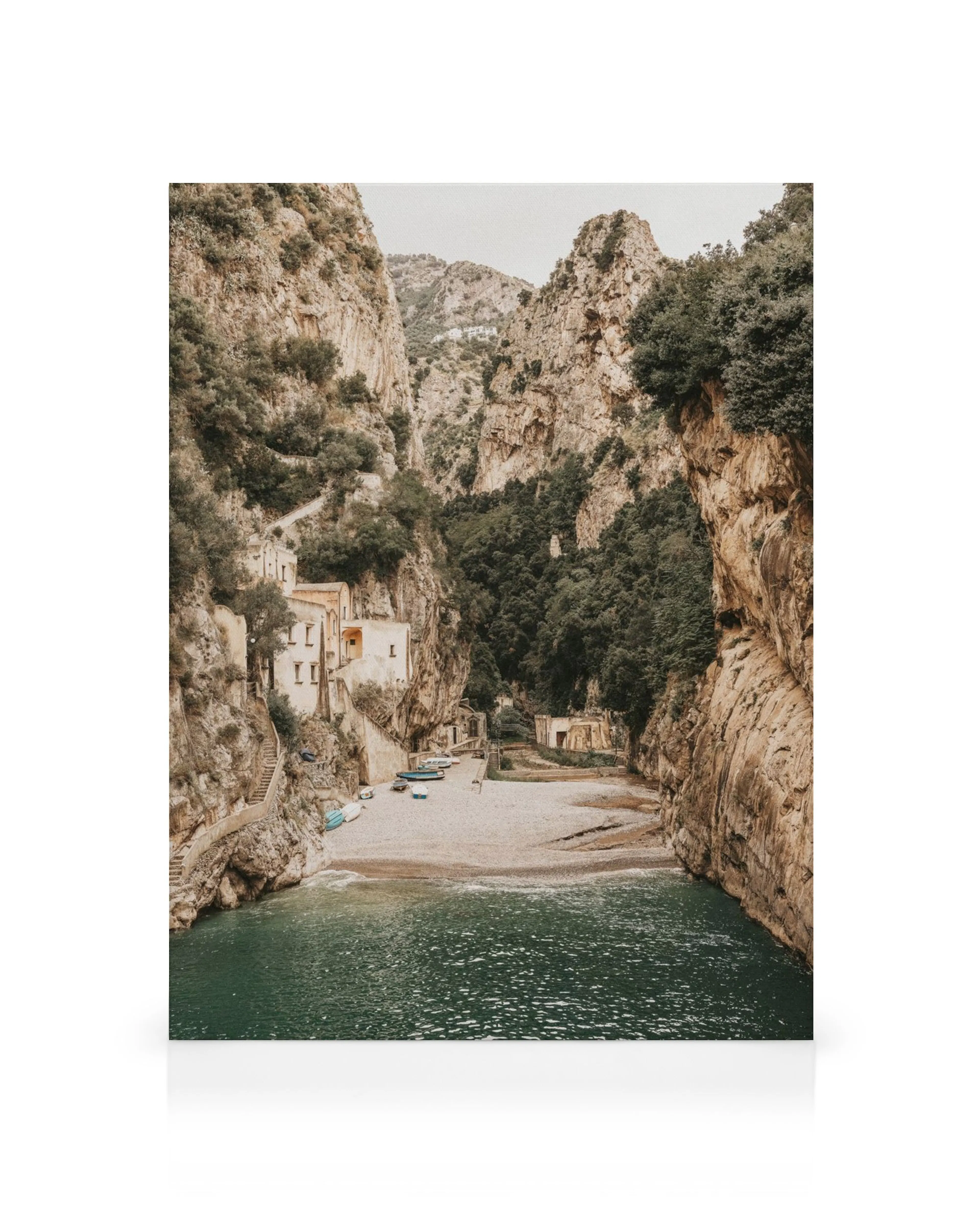 A canvas print featuring a hidden beach with blue-green water and tall rocky cliffs surrounding it.