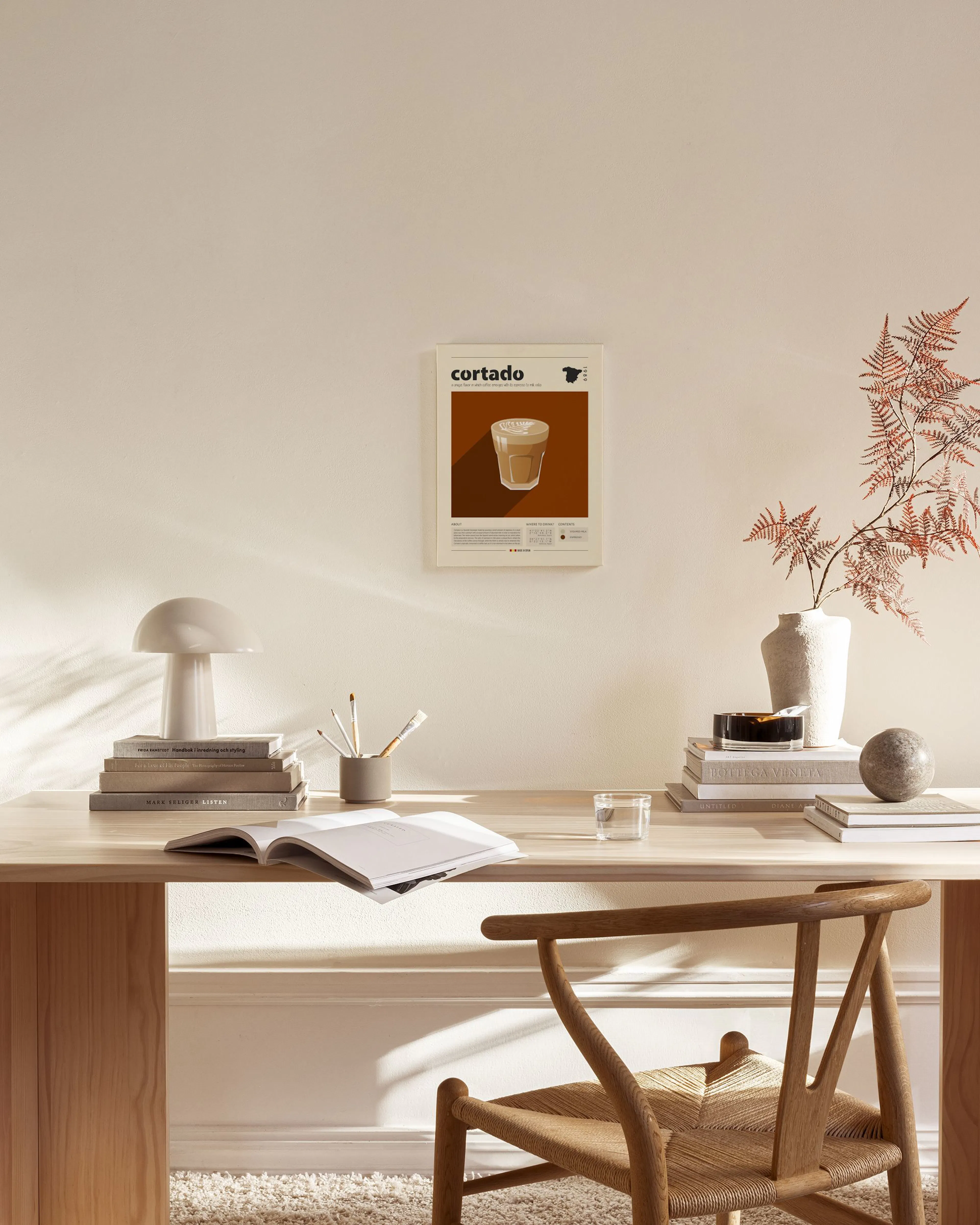 A canvas print advertising cortado coffee with an illustration of a cortado in a glass, on a brown and beige background.
