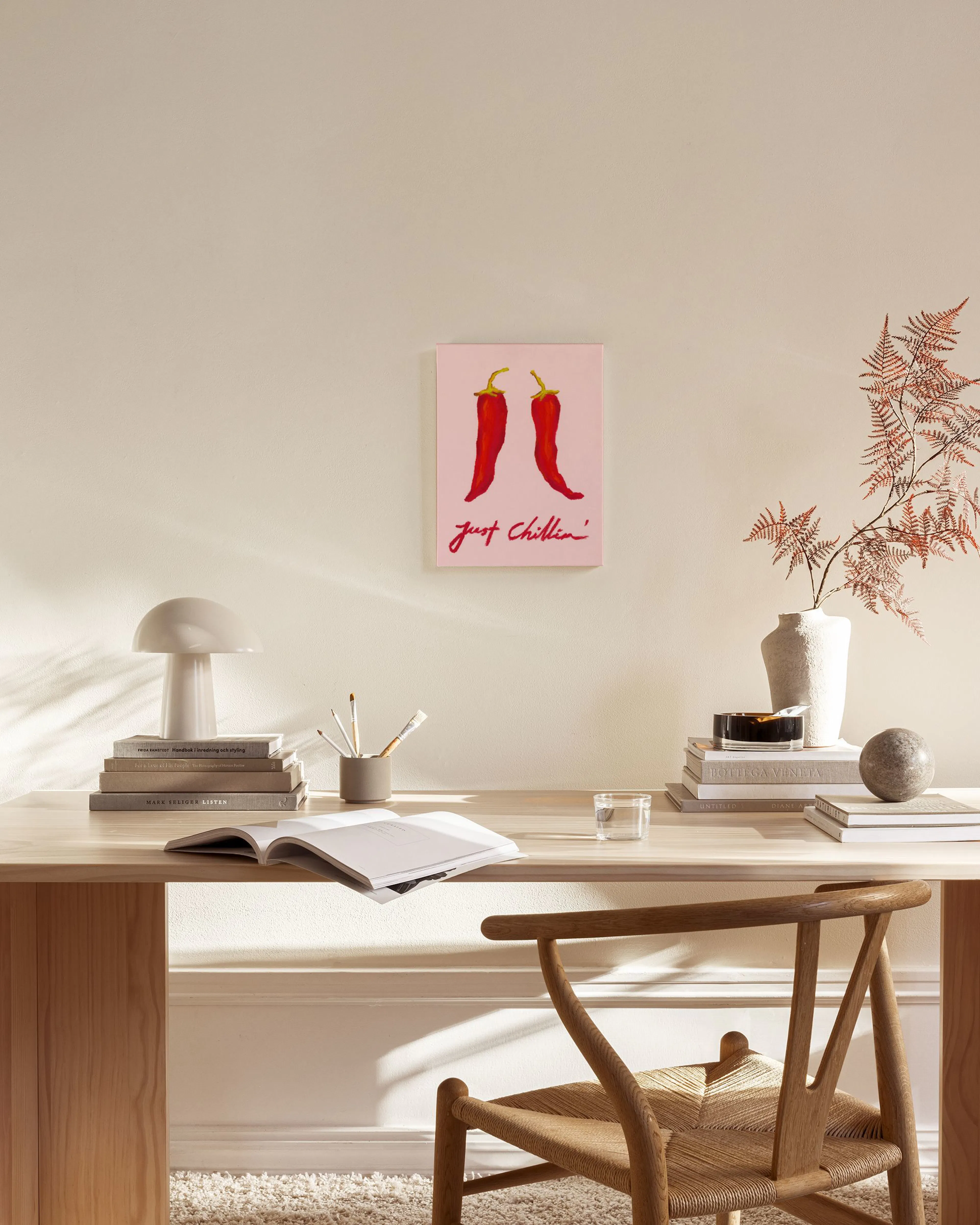 Canvas print featuring two red chili peppers with yellow stems on a pink background, with the words Just Chillin in red script b