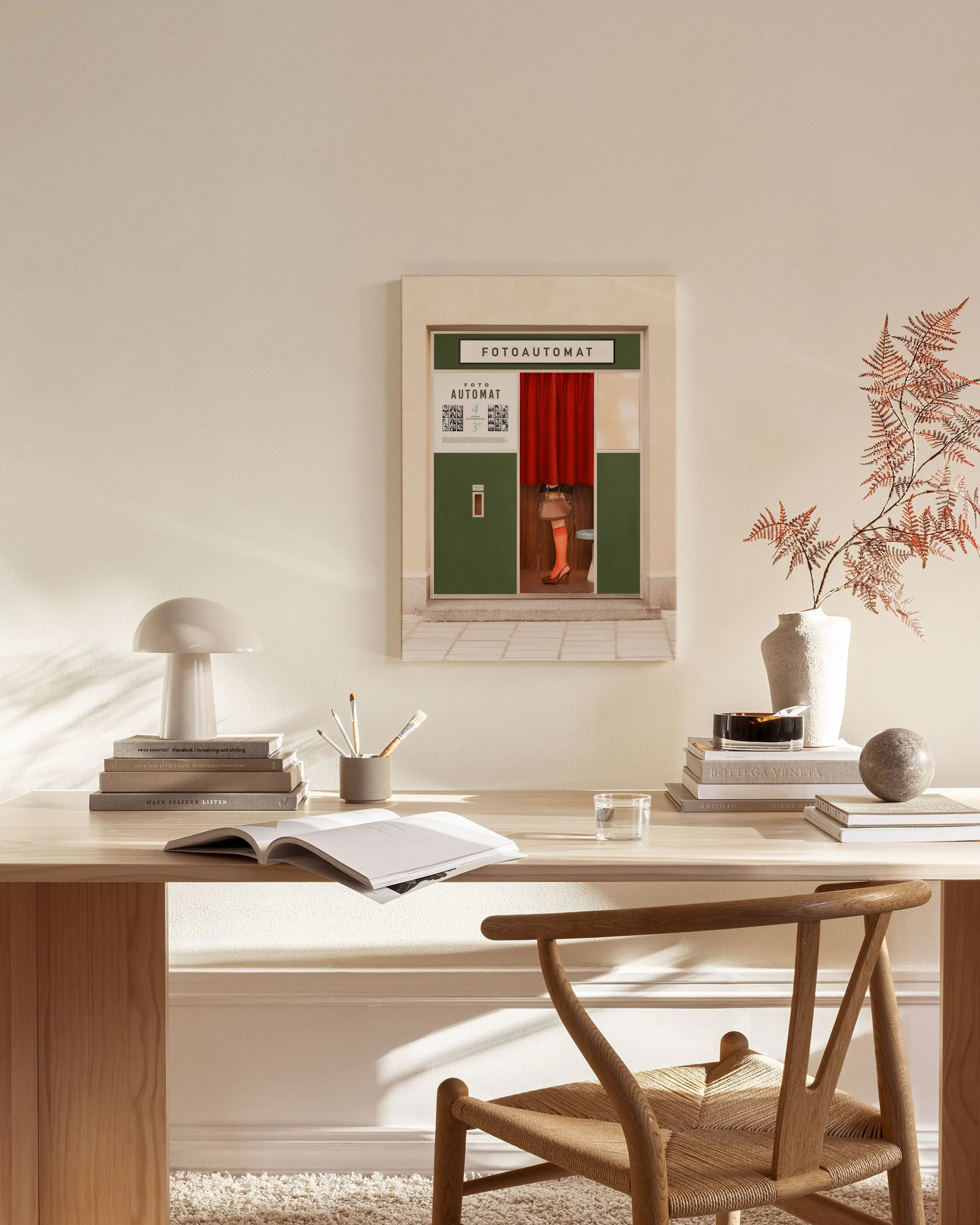 Canvas van een fotohokje met een rood gordijn waar benen onderuit steken, hangend in een neutrale woonkamer.