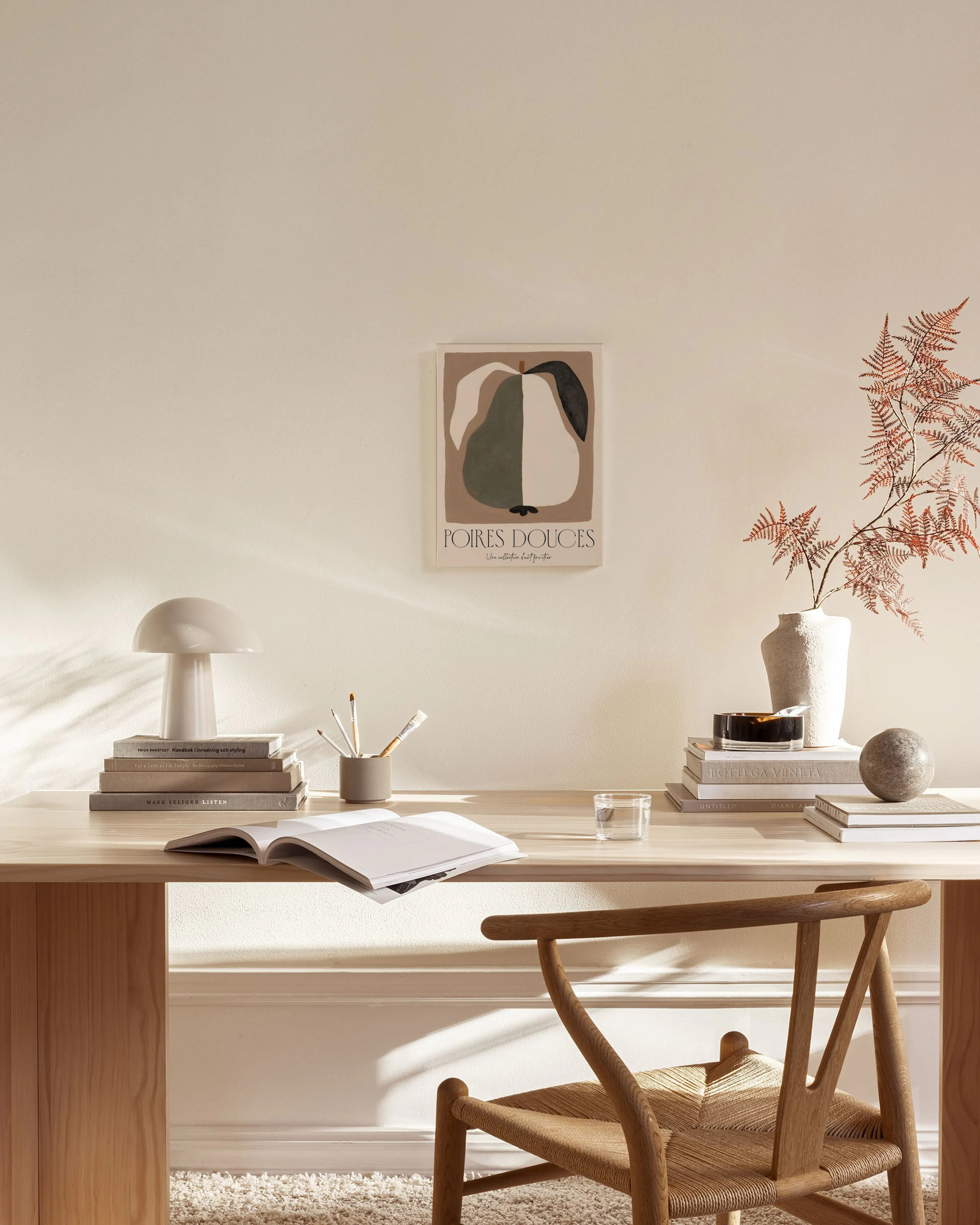 Lerretsbilde av en stilisert pære i grå, beige og mørkebrune nyanser, hengende over et sidebord i en moderne stue.