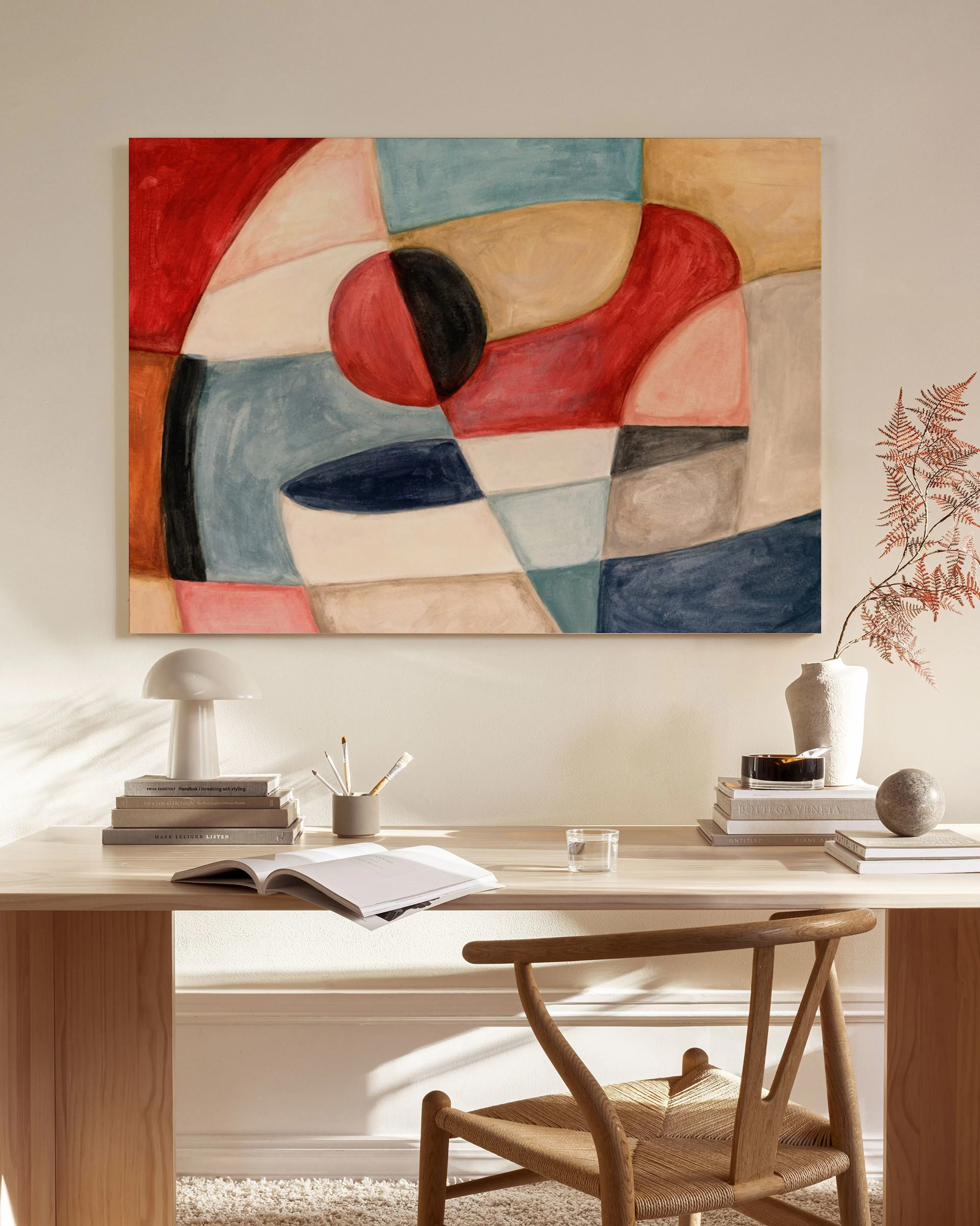 Abstract canvas print with colourful organic shapes and lines, hanging in a minimalist living room above a wooden console.