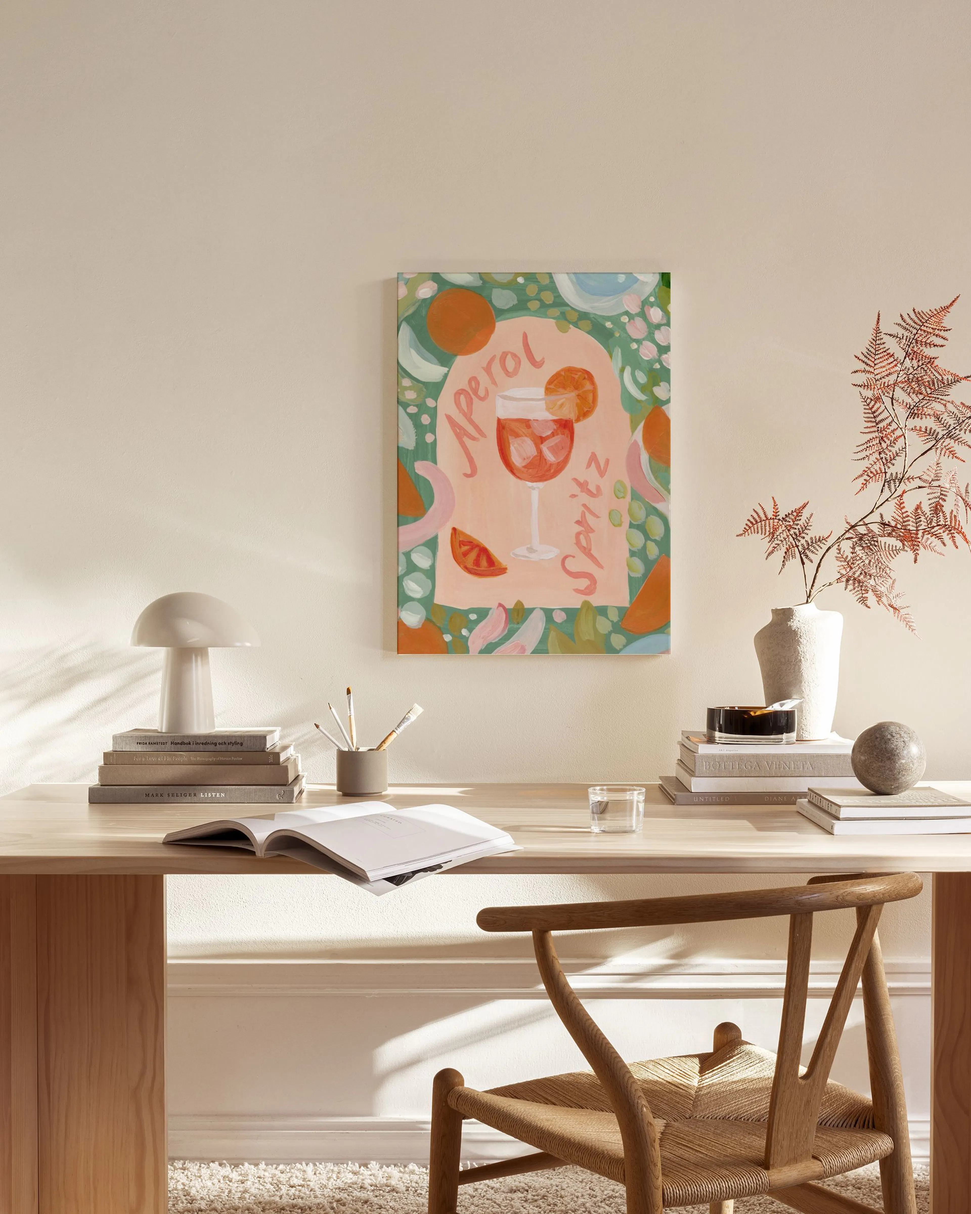 Toile Aperol Spritz à laquarelle, avec des oranges et des formes abstraites, exposée dans un salon moderne.
