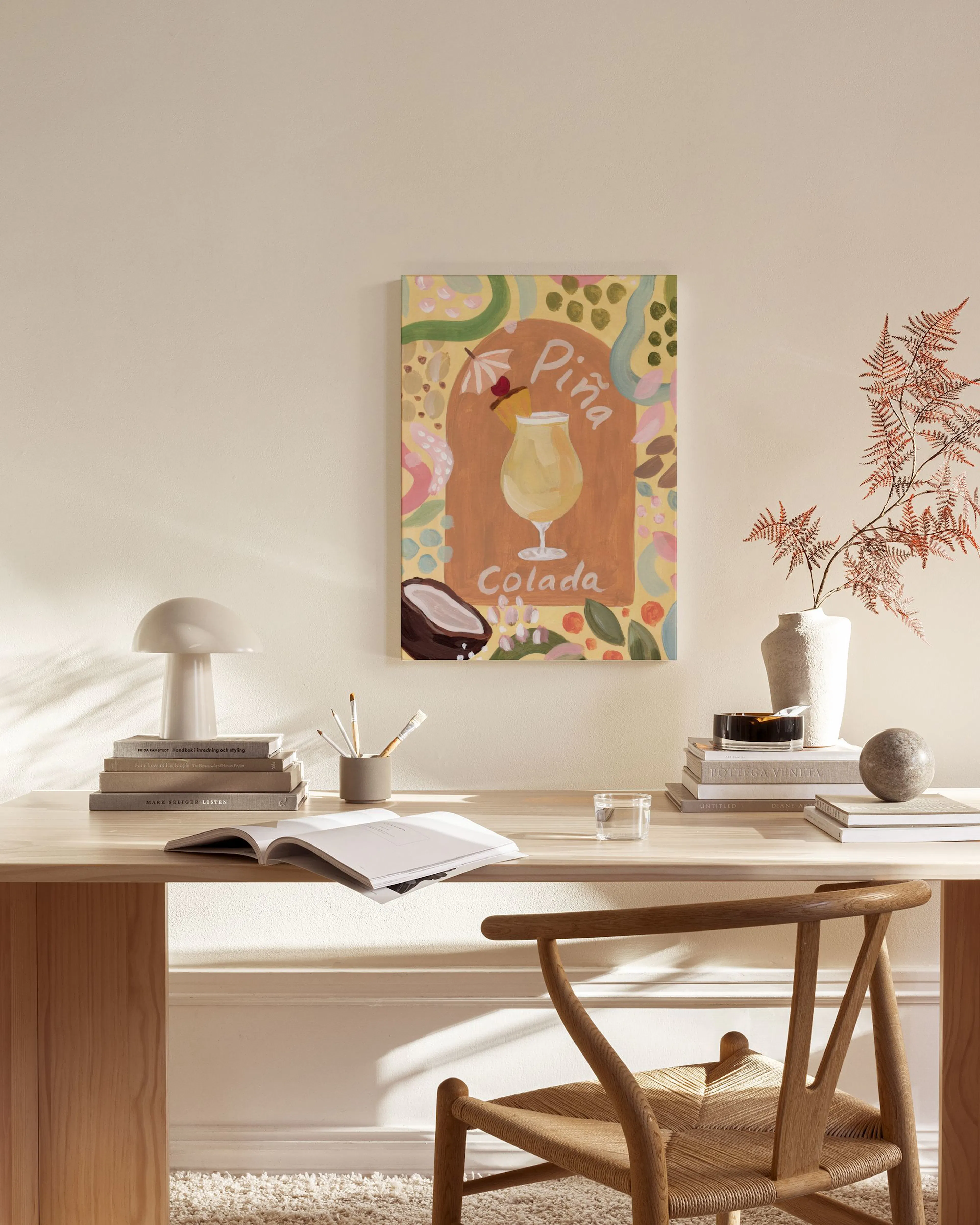 Stampa su tela Piña Colada appesa in un soggiorno moderno con mobili in legno e tavolino in vetro.