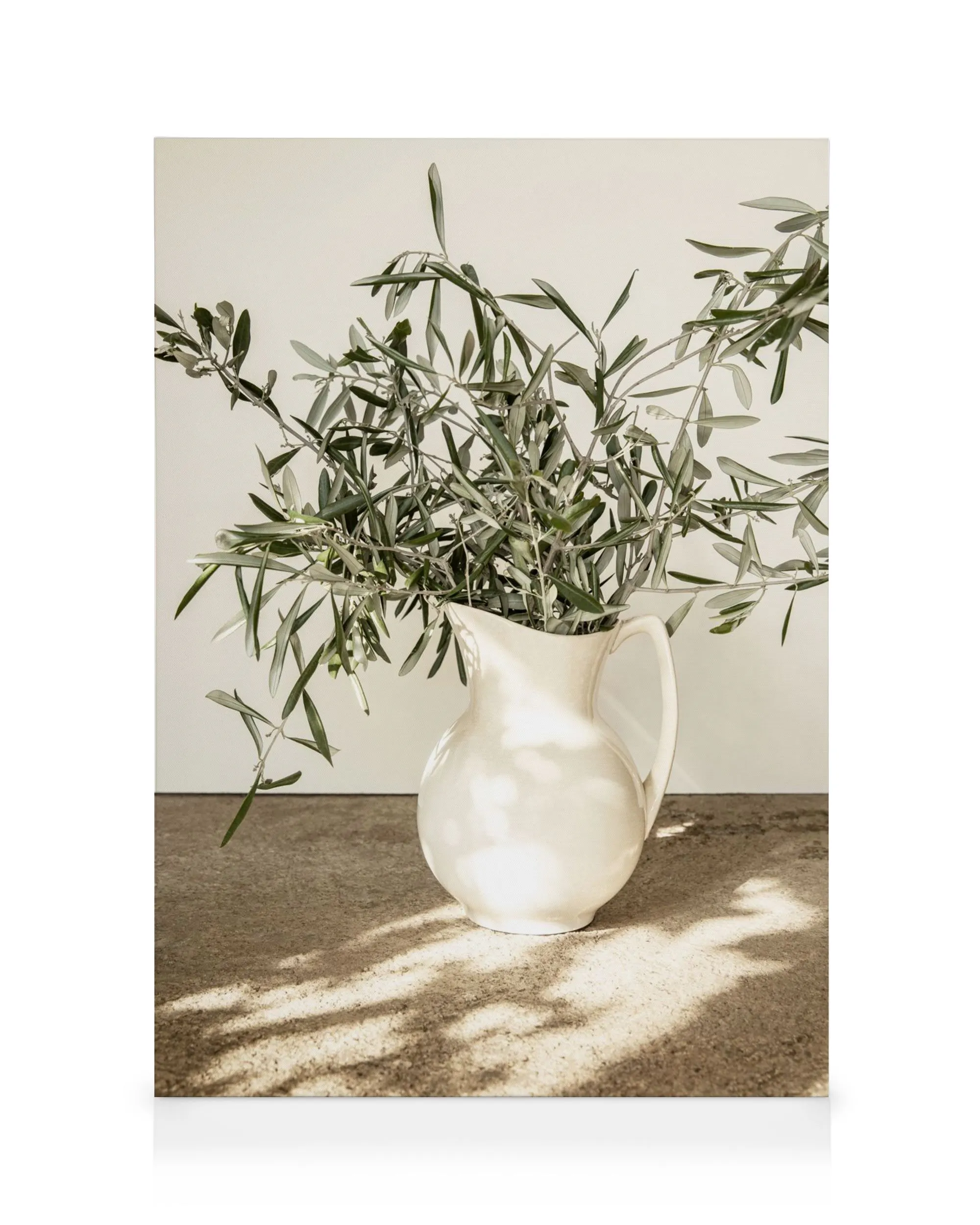 Toile présentant des branches dolivier vert foncé et gris clair dans un vase blanc cassé, avec des jeux dombre et de lumière.