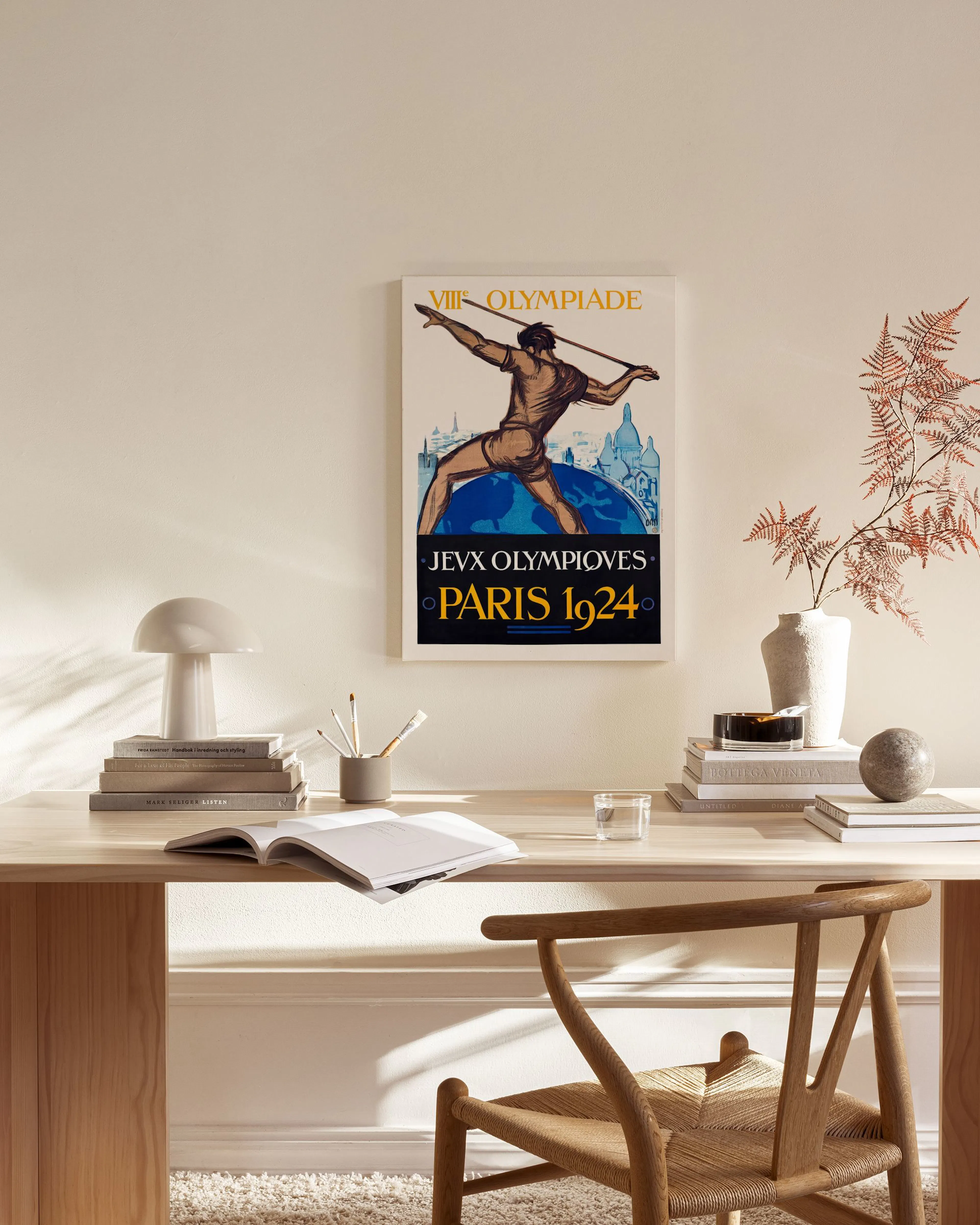 Obraz na plátne s retro plagátom olympiády v Paríži 1924, visiaci nad modernou drevenou komodou v obývačke.
