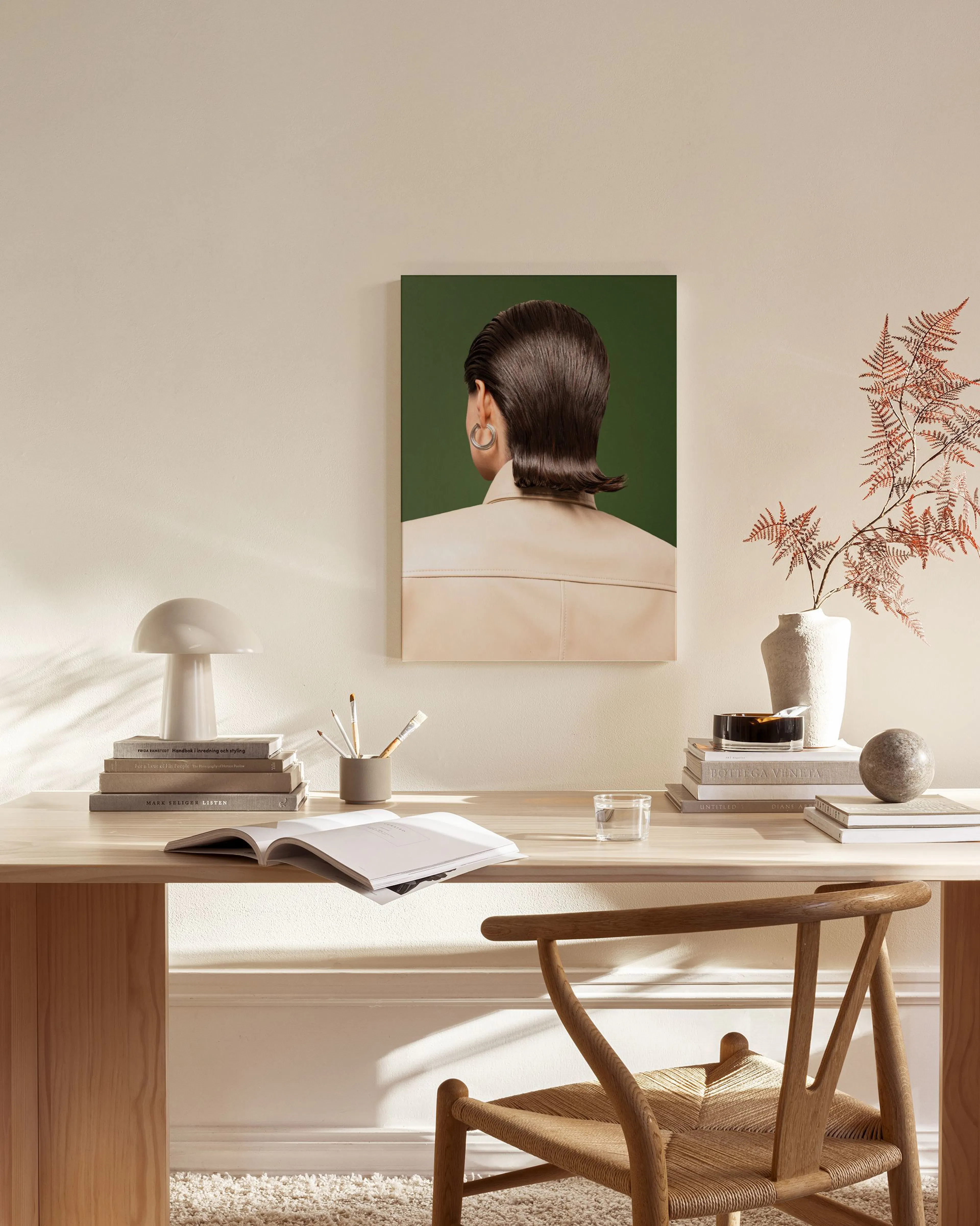 Toile dune silhouette de dos avec cheveux bruns lissés et chemise beige, suspendue dans un salon moderne.