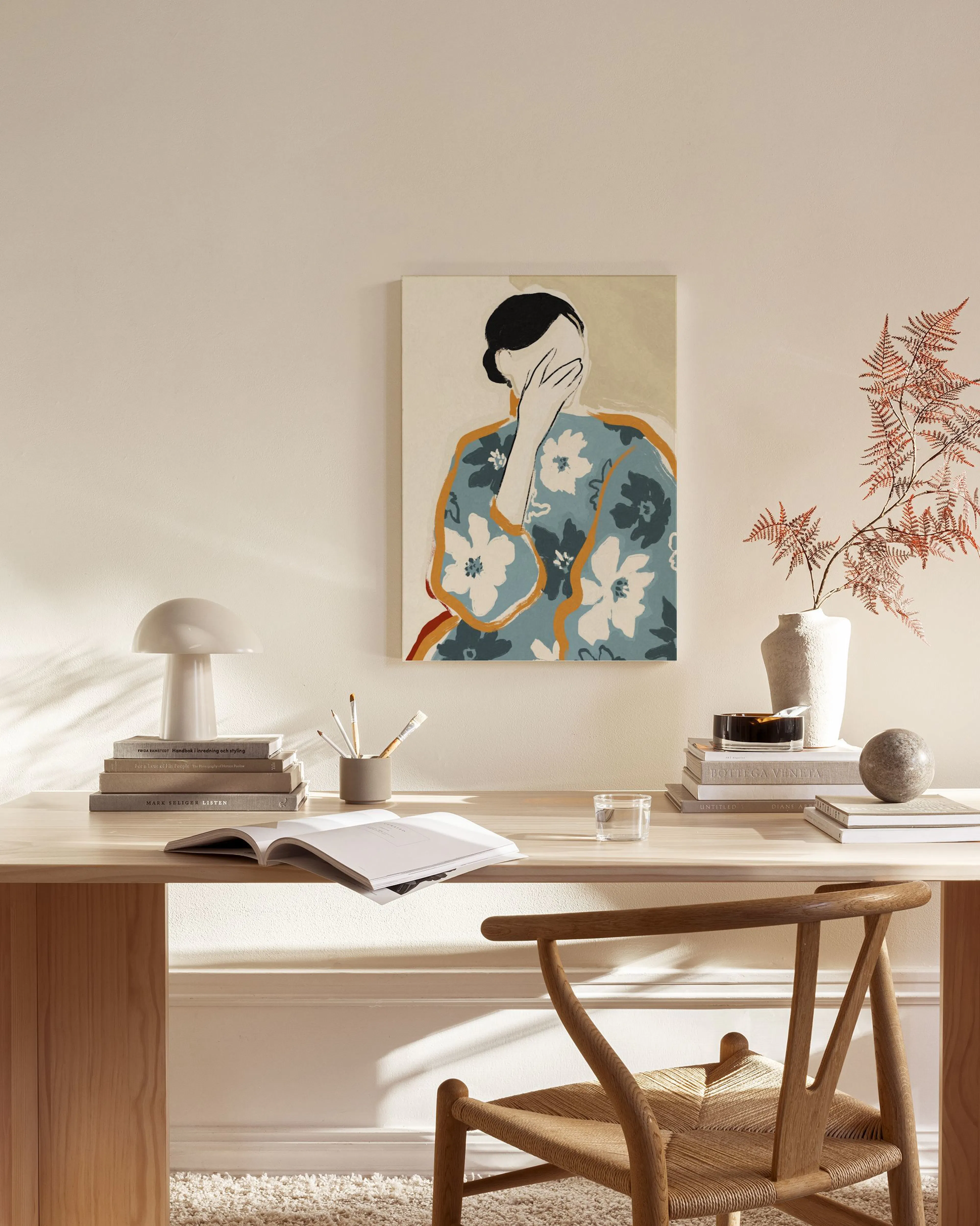 Abstract canvas print of a woman in a blue kimono with white flowers covering her face, hanging in a modern living room.