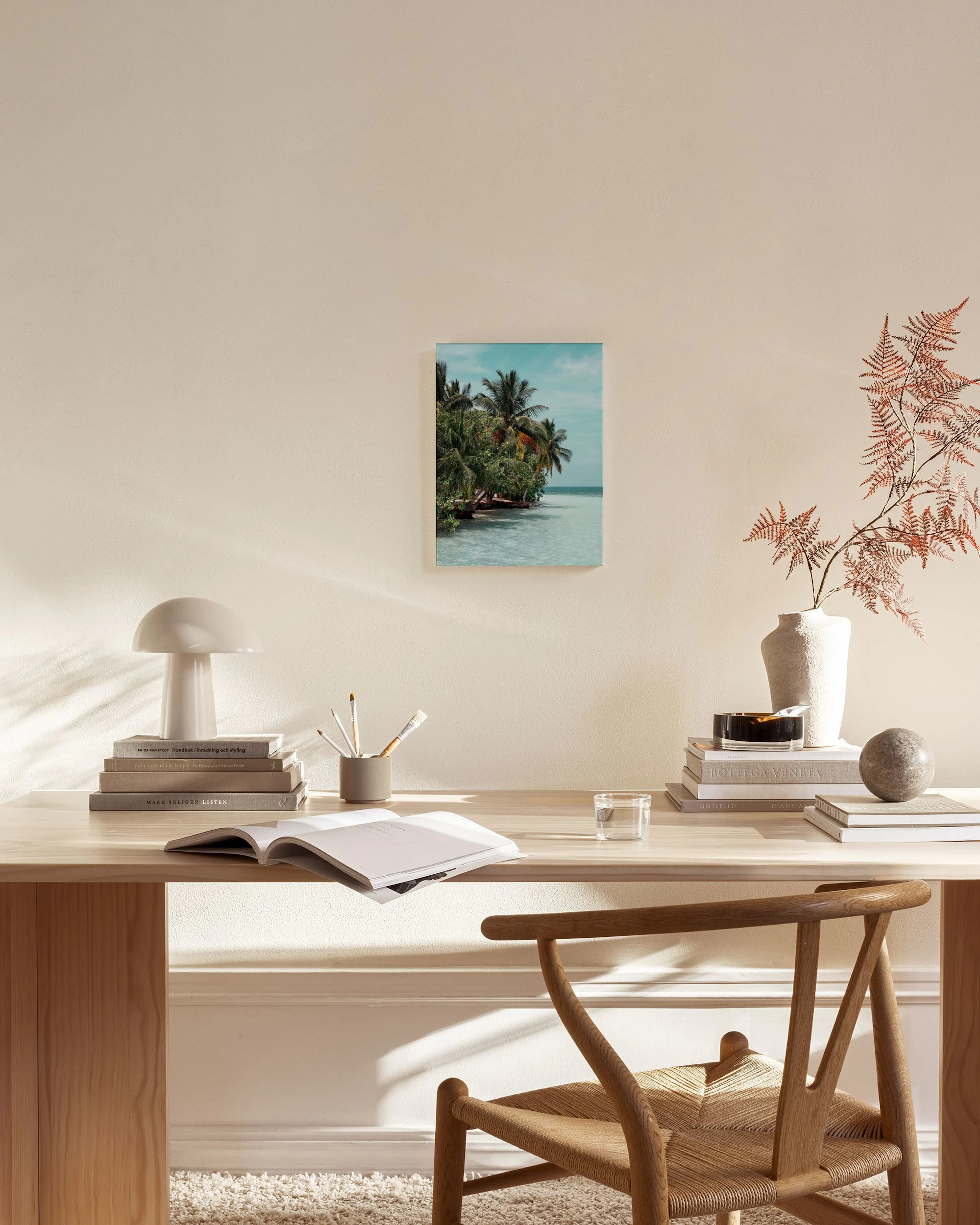 Canvas met tropisch strand en palmbomen bij helderblauw water, hangend in een lichte woonkamer.