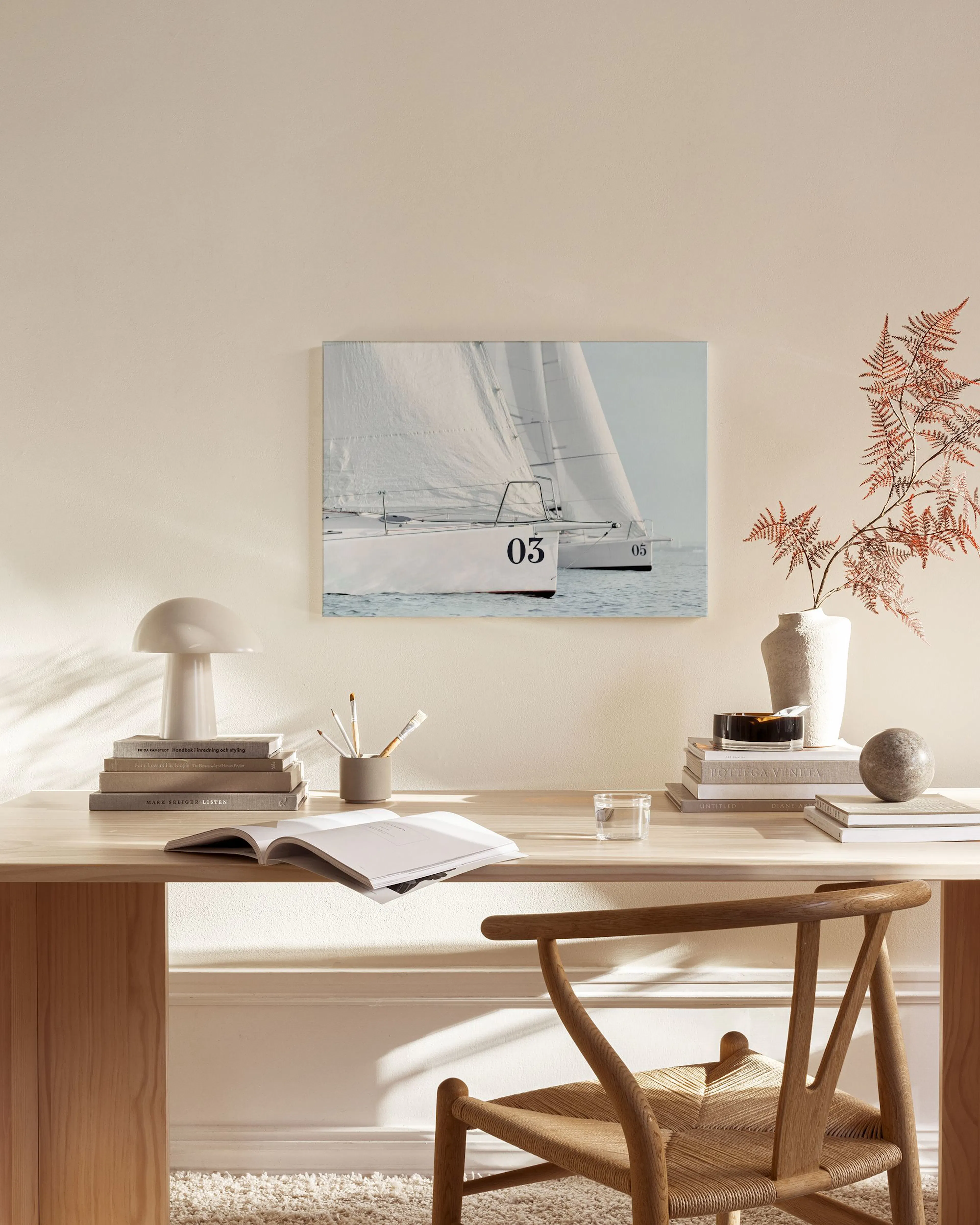 Toile d’un voilier blanc immatriculé 03 sur l’eau, suspendue dans un salon moderne aux tons neutres.