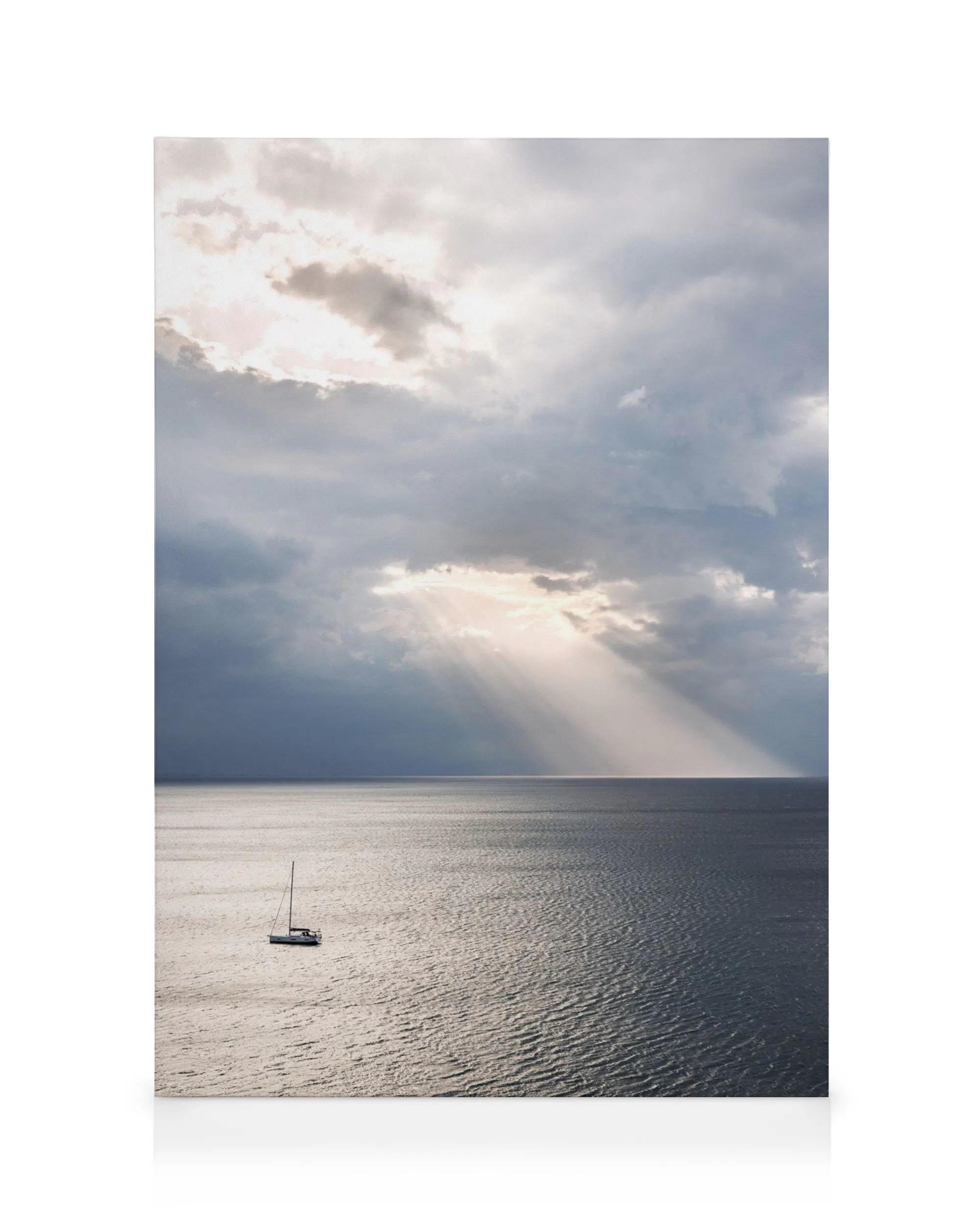 Segelboot auf ruhigem Wasser unter dramatischen Wolken, Sonnenstrahlen durchbrechen die Wolkendecke, friedliche Szene.