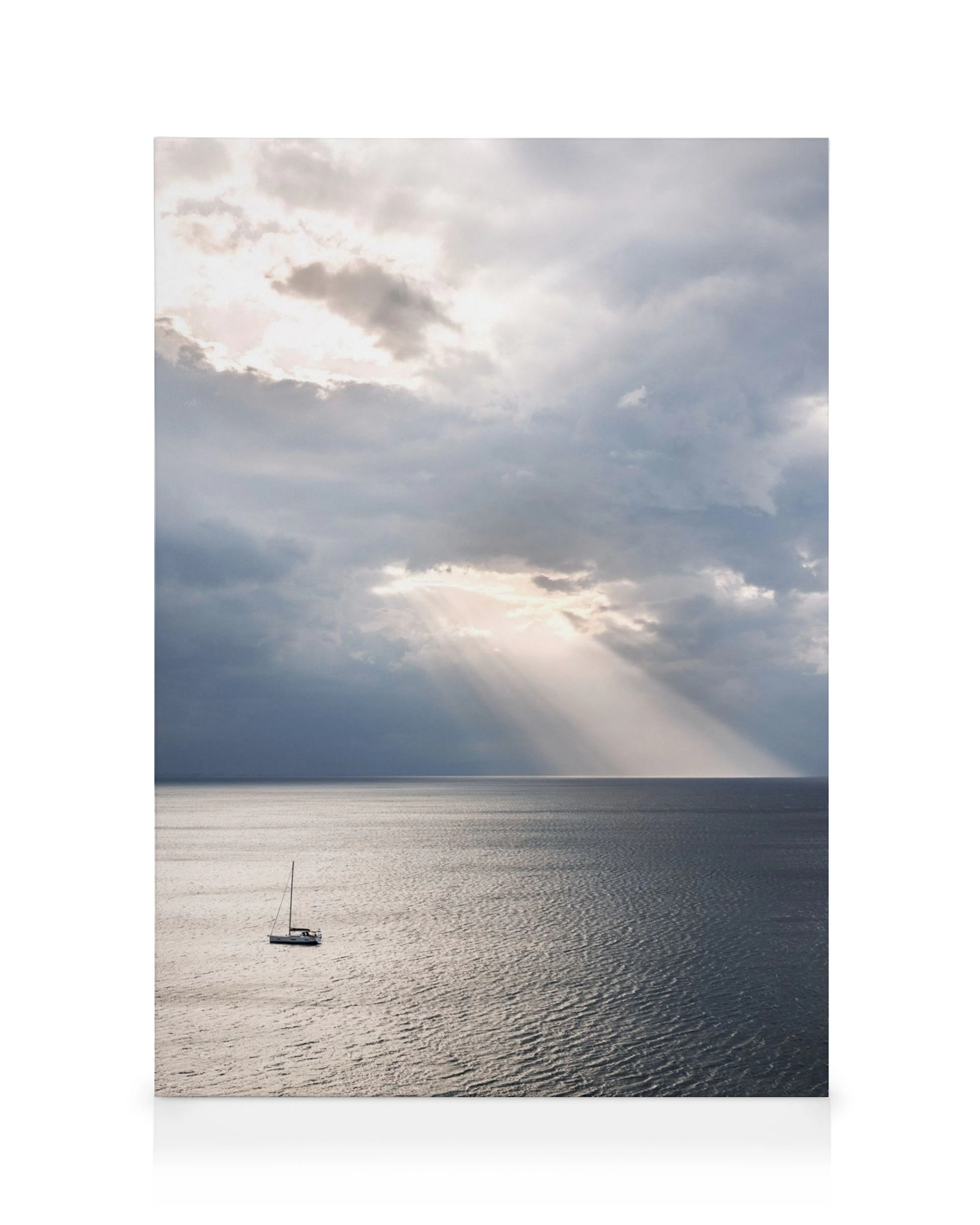Segelboot auf ruhigem Wasser unter dramatischen Wolken, Sonnenstrahlen durchbrechen die Wolkendecke, friedliche Szene.